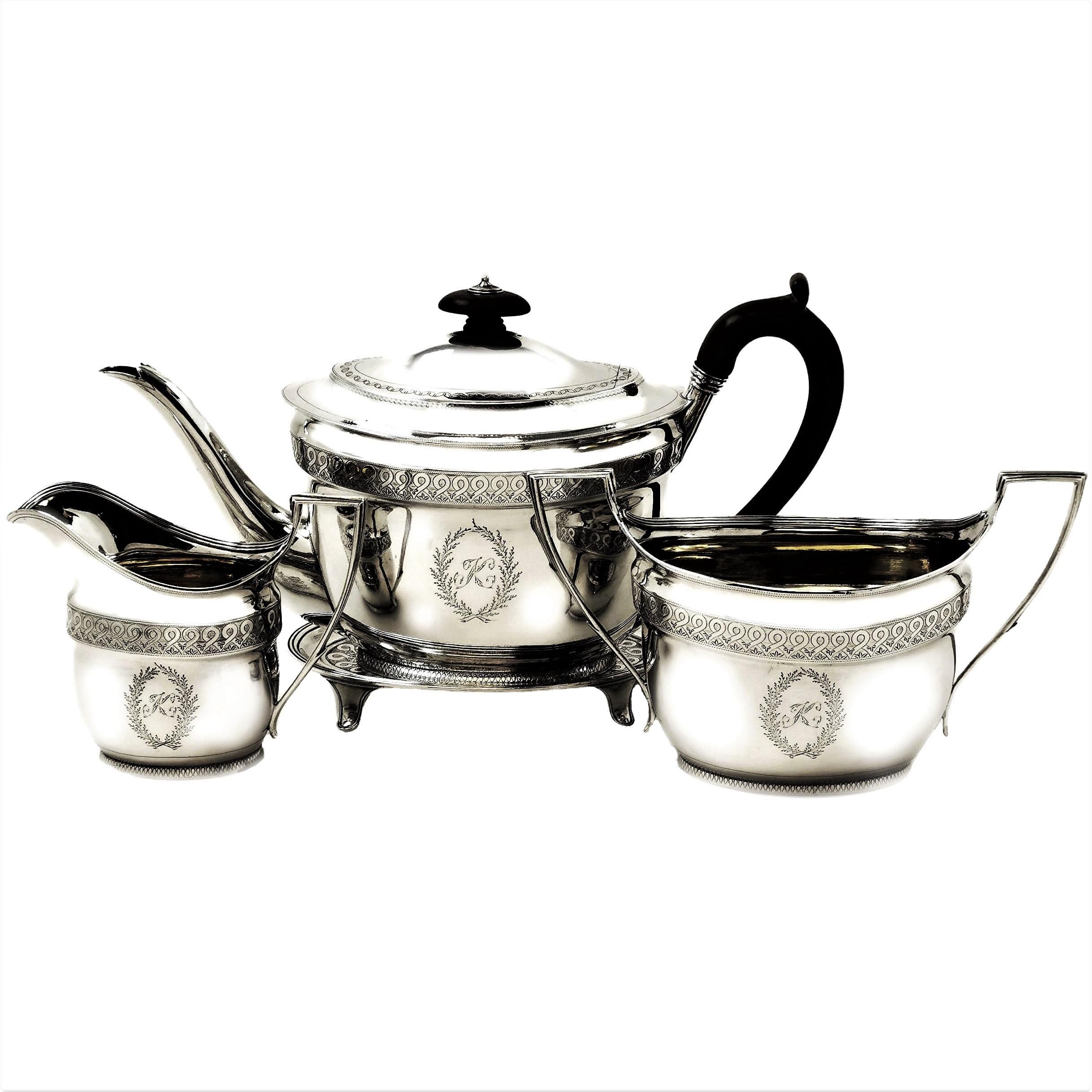 A lovely Antique George III solid Silver four piece Tea Set comprising of a Teapot on Tray, a Cream / Milk Jug and a Sugar Bowl. Each piece is embellished with a delicate engraved band and an engraved crest on one side and a monogram on the other.