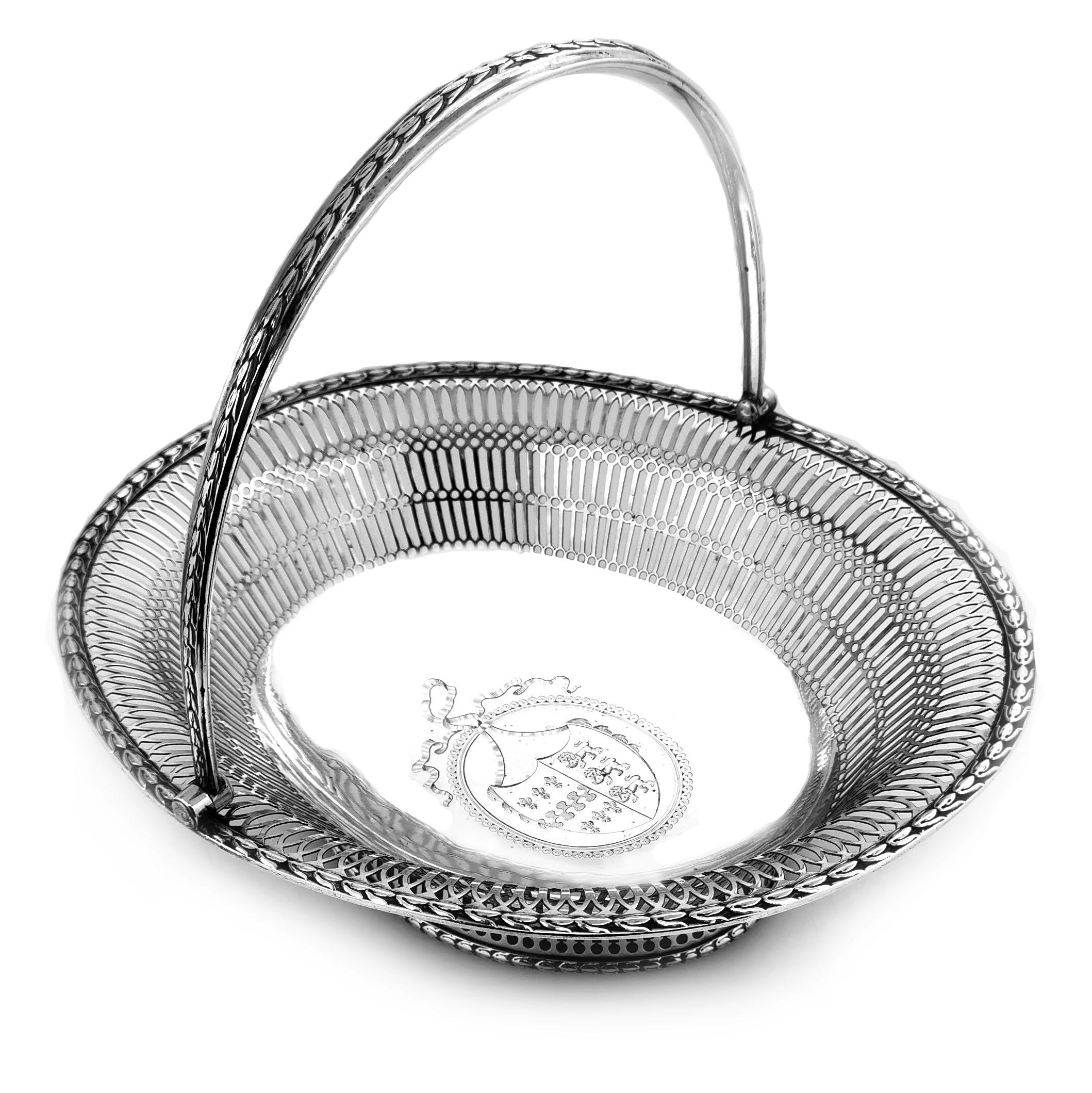 A magnificent antique George III solid Silver swing handled Cake Basket in a classic oval shape. This Silver Georgian Basket has an elegant pierced pattern on the sides and rim of the body and the pedestal foot. This decorative serving Basket had a