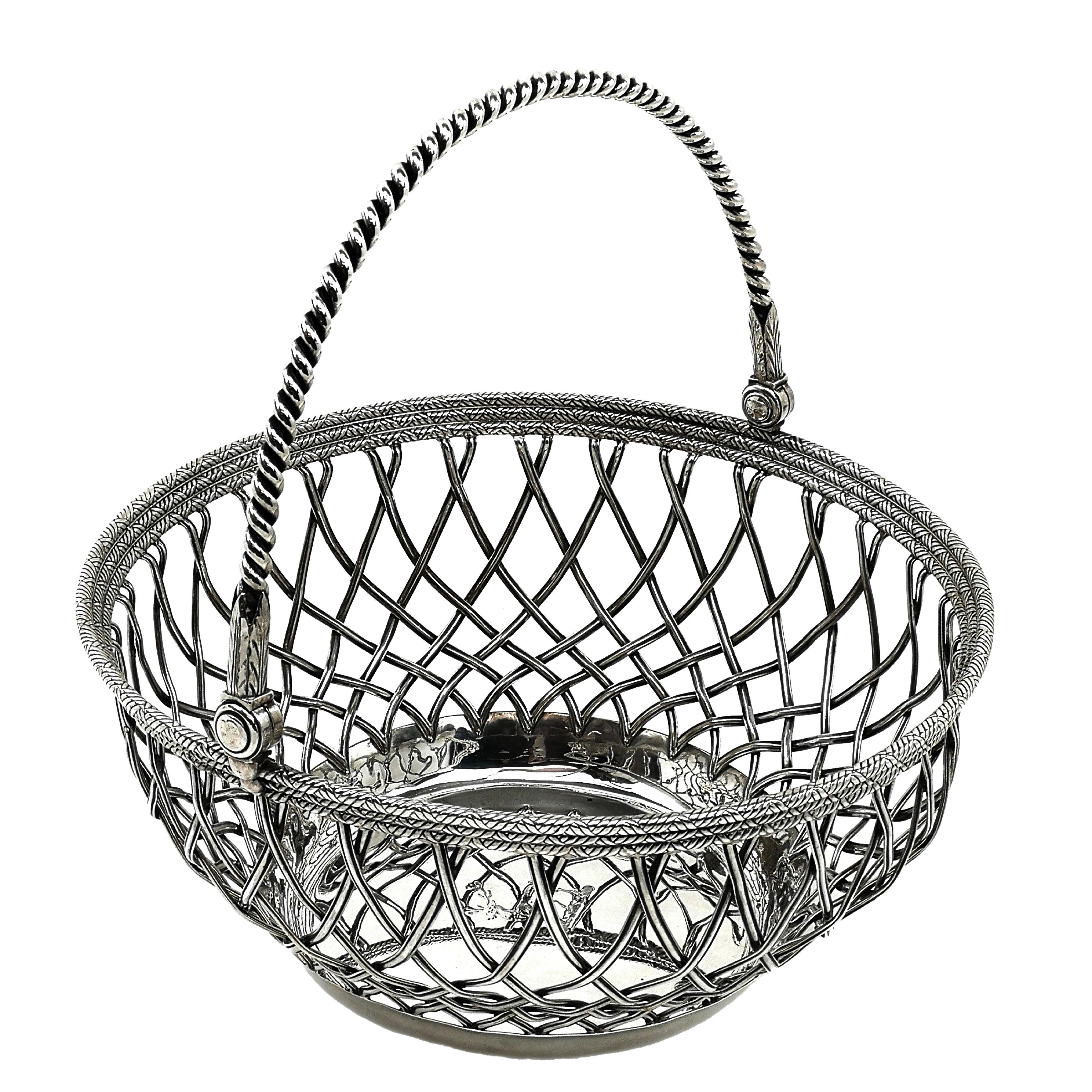 A magnificent George III Solid Silver Basket with a round form and a traditional swing handle. The Basket has a Solid Base and elegant sides created through silver wire work to mirror a basket weave. The Rim of the basket has cross hatches to