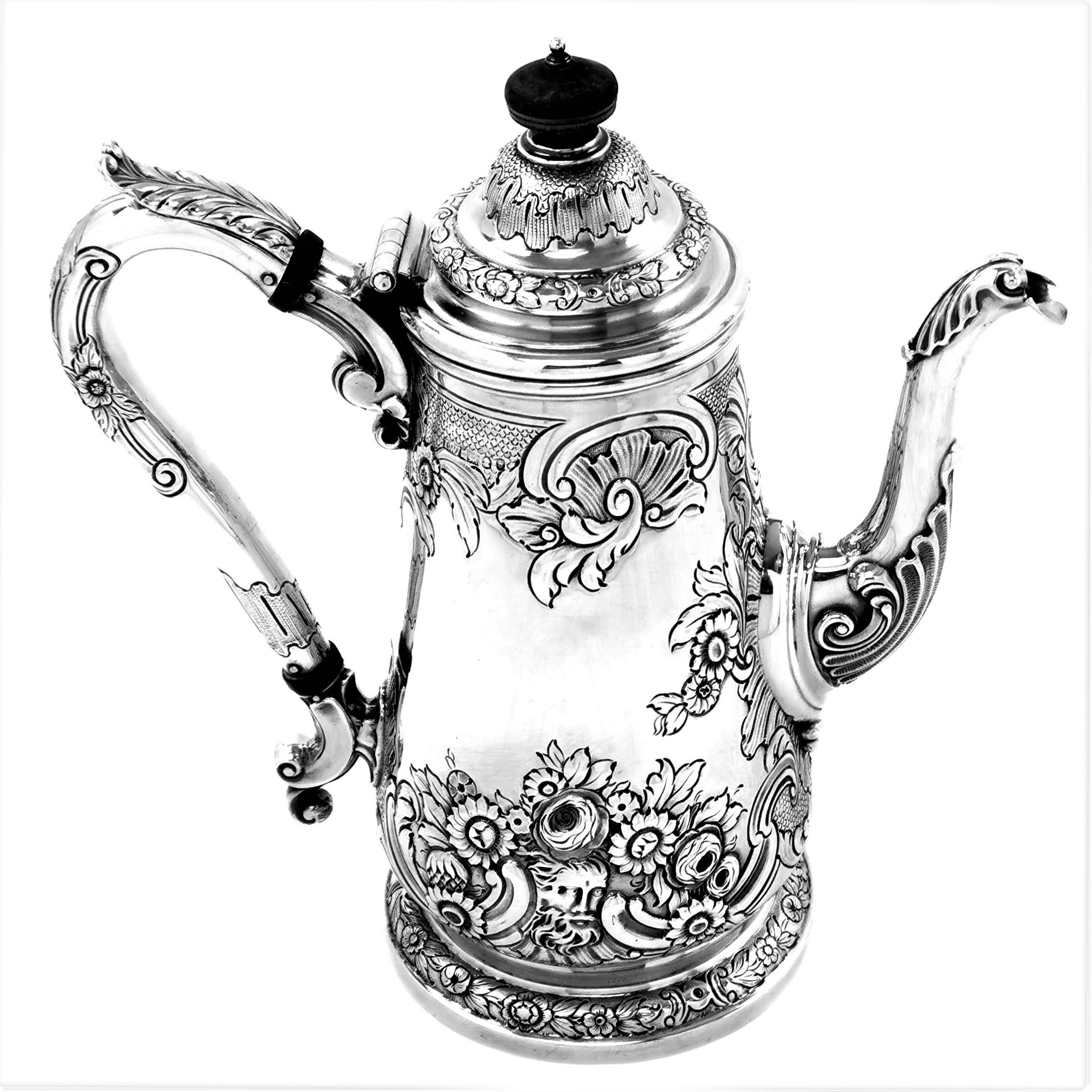 A beautiful antique George IV solid Silver Coffee Pot featuring a lovely chased design showing stylized floral and scroll patterning with shell designs on the spout. The chased designs are continued onto the circular foot and the elegant handle. The