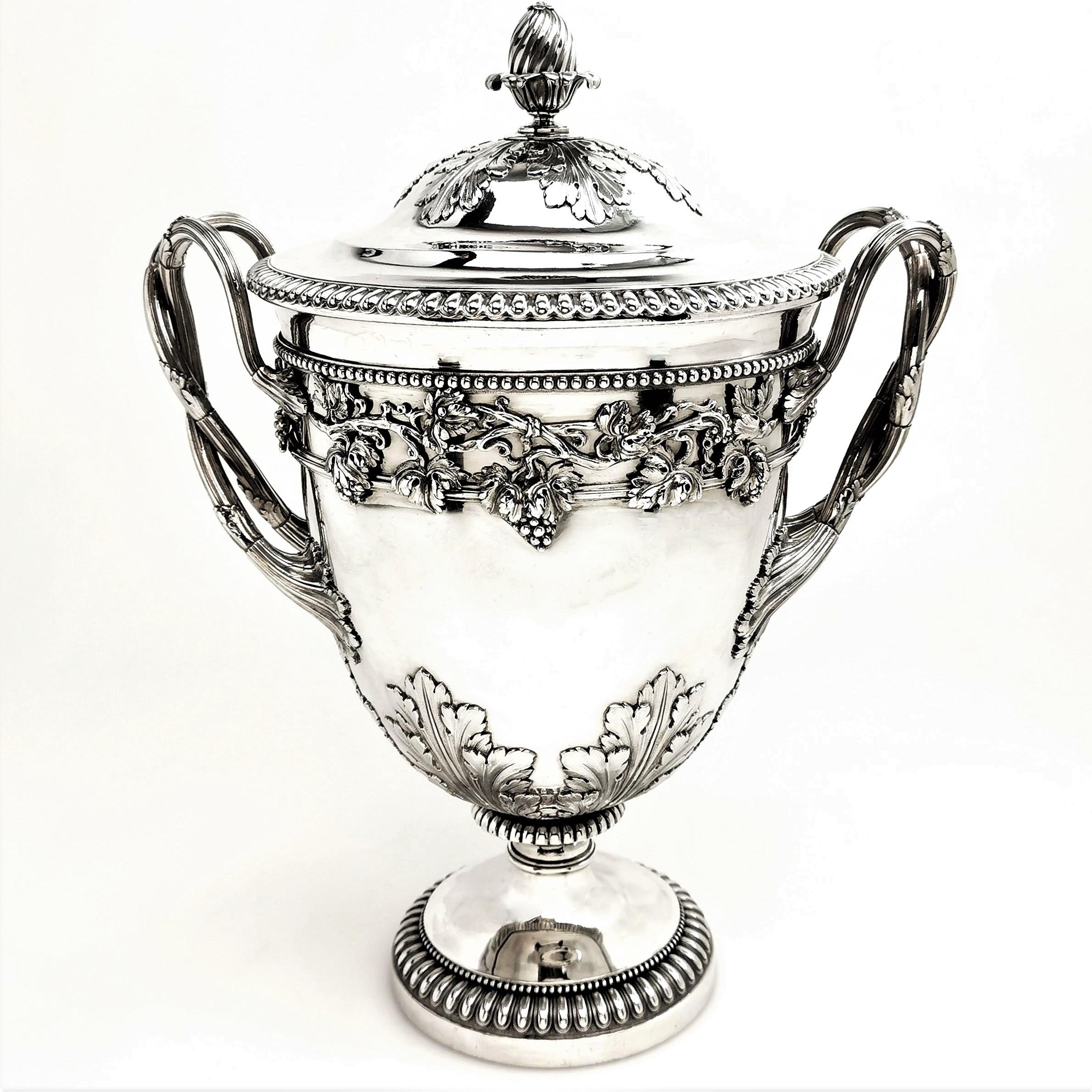 An impressive George III Antique solid Silver Cup & Cover featuring a beautiful embellished exterior. The Cup has a pair of leaf decorated handles, each a pair of intertwined branches. The handles join a detailed applied vine, grape and leaf band