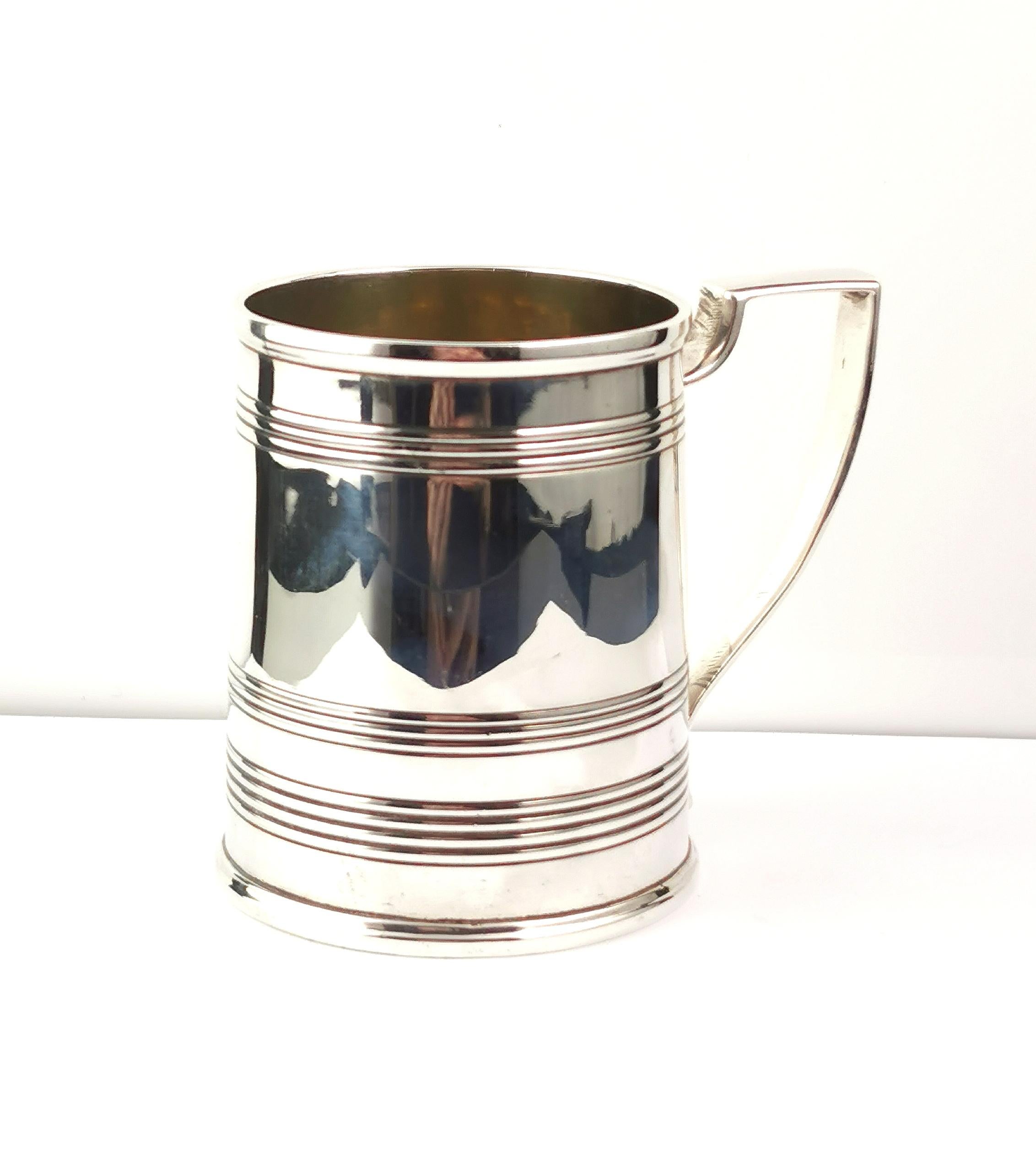 A delightful antique Georgian era sterling silver mug or tankard.

It has an engraved design to the upper half and lower half with a smooth finish on the mid section.

It has a squared scrolling handle, a half pint mug, it still has a lovely gilt