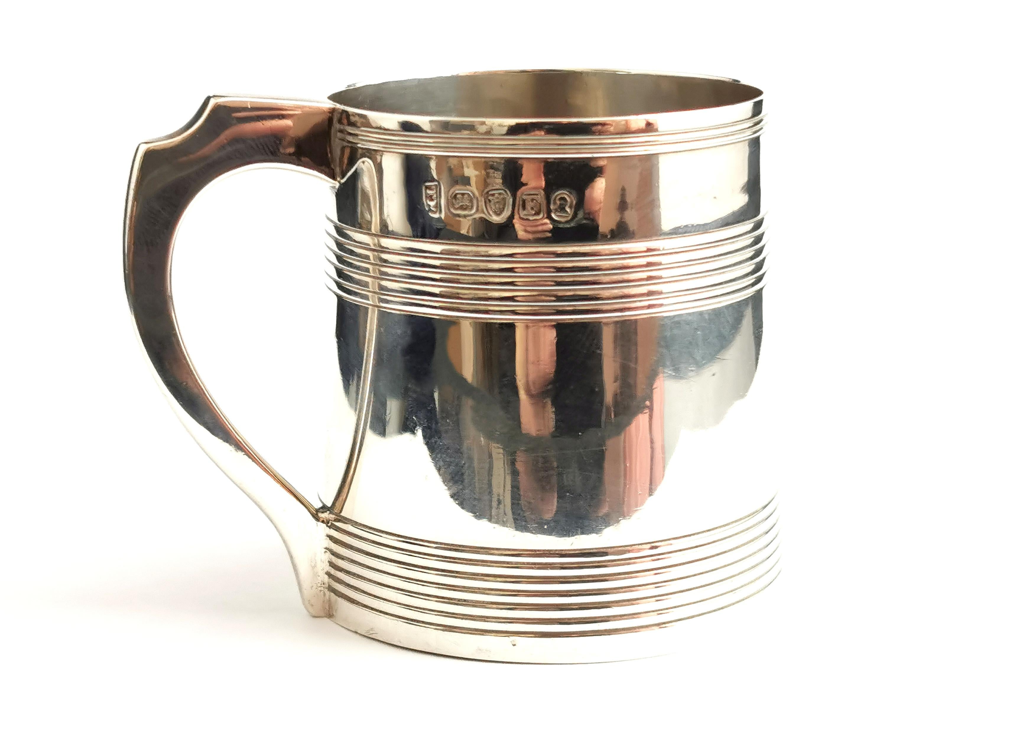 A delightful antique Georgian era sterling silver mug.

It has a reeded gadrooned design to the upper half.

A smaller sized mug and a squared scrolling handle, possibly a christening mug or half pint mug.

It is made from solid sterling