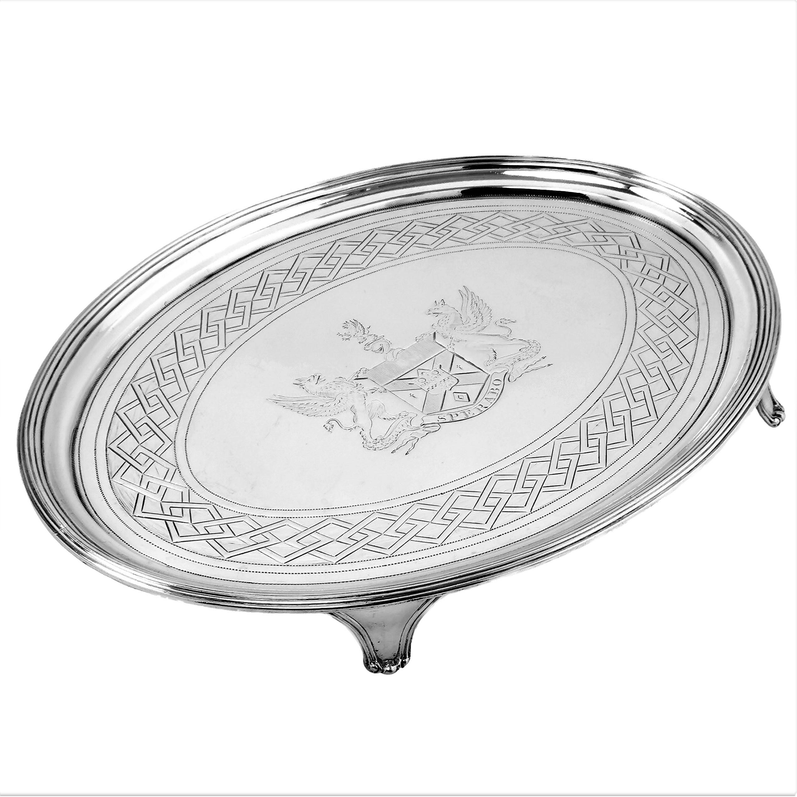 An elegant Antique George III solid Silver Oval Salver with an impressive engraved armorial in the centre and a geometric repeating engraved band around the edge of the Tray. The rim of the Salver has a The Salver stands on four shaped feet.

Made