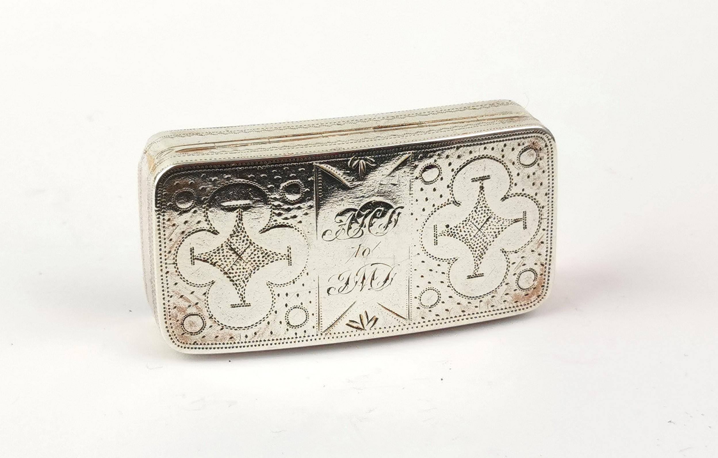 A fantastic antique Georgian era sterling silver snuff box.

It has an interesting bright cut engraved design both top and bottom with initials to the top in fancy script.

The box has an ergonomic curved profile and retains its lovely rich golden