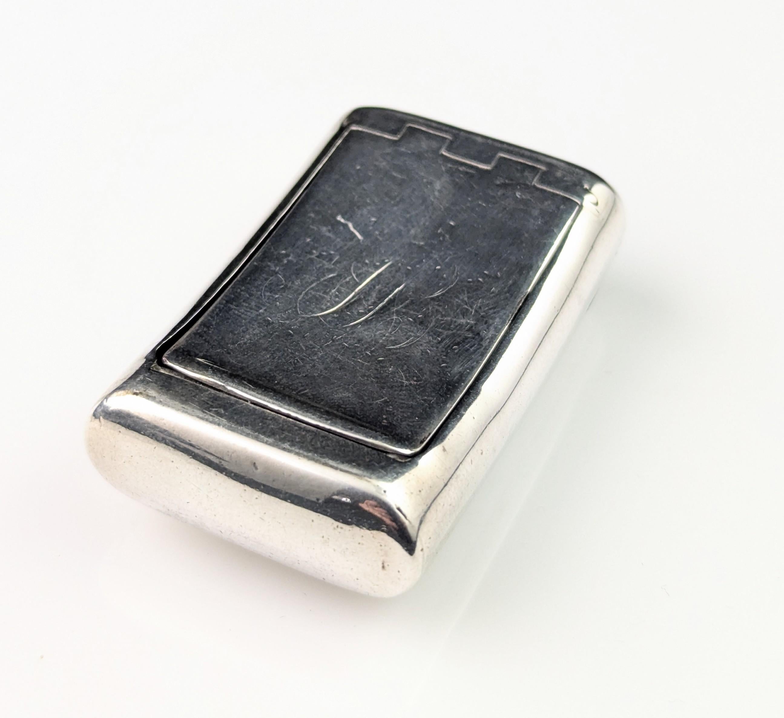 An attractive antique Georgian era sterling silver snuff box.

It has an ergonomic design which easily slips into the pocket it is a bowed shape and has a squeeze / push action closure.

The top is engraved with initials in fancy script but this is