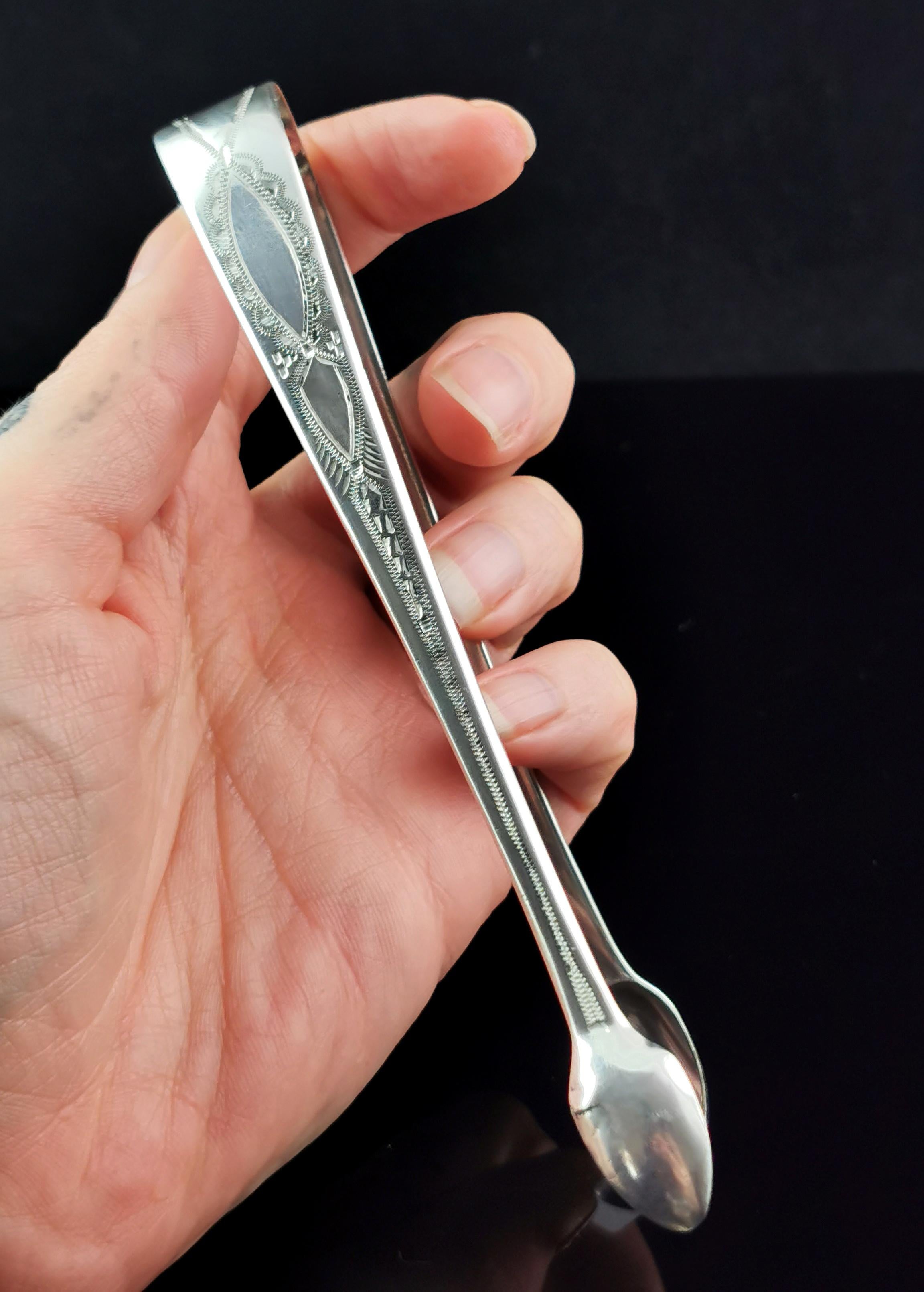 A very attractive pair of antique Georgian era sterling silver sugar tongs.

Featuring decorative bright cut engraving and slender bowls, they are a larger pair and quite substantial with crisp hallmarks.

Fully hallmarked for London, 1812,