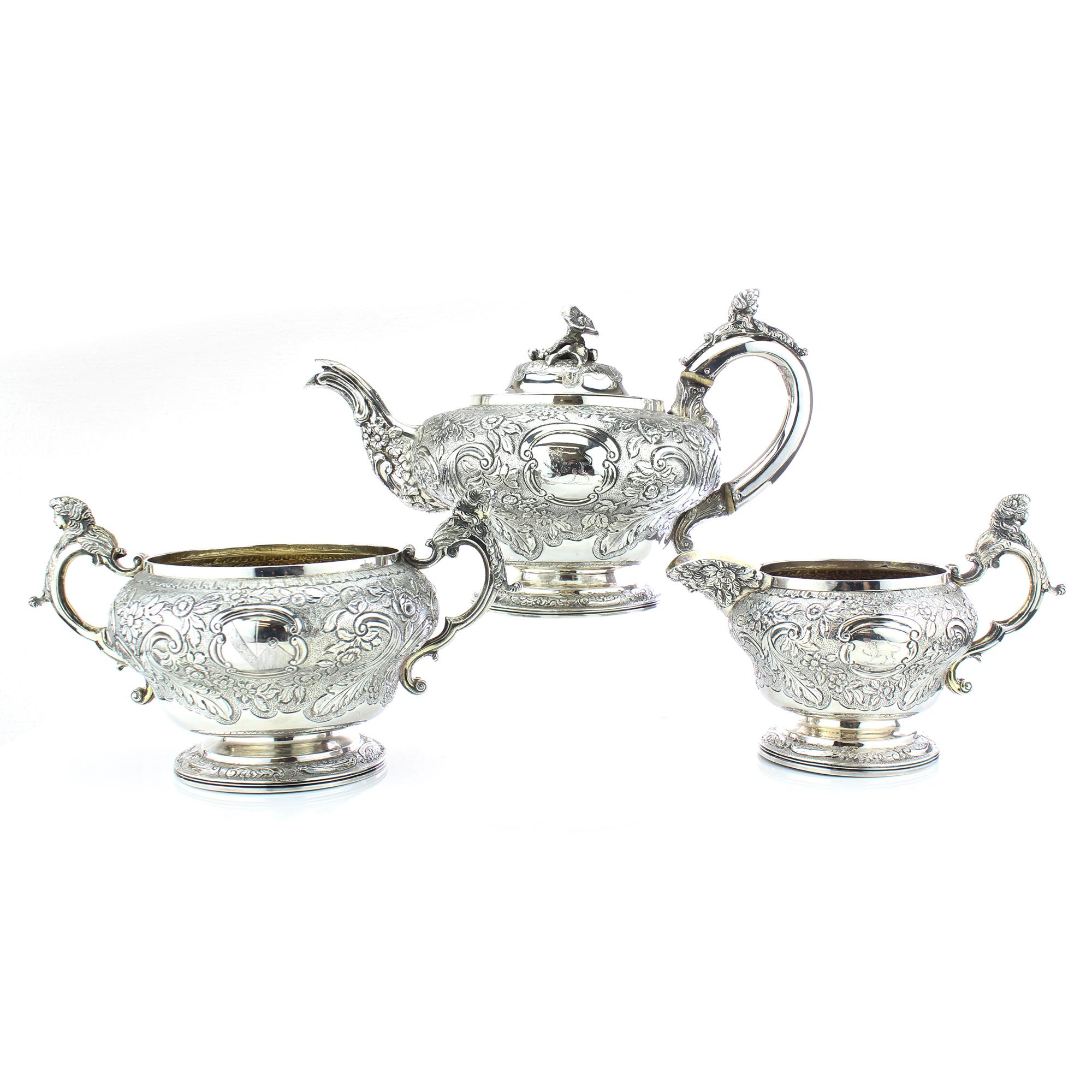 Antique Georgian sterling silver three-piece elaborately engraved tea service set.

The elegant Georgian era tea service has a design of intertwined C-scrolls, thumbprints and baguette motifs that are simply beautiful. The delicately polished