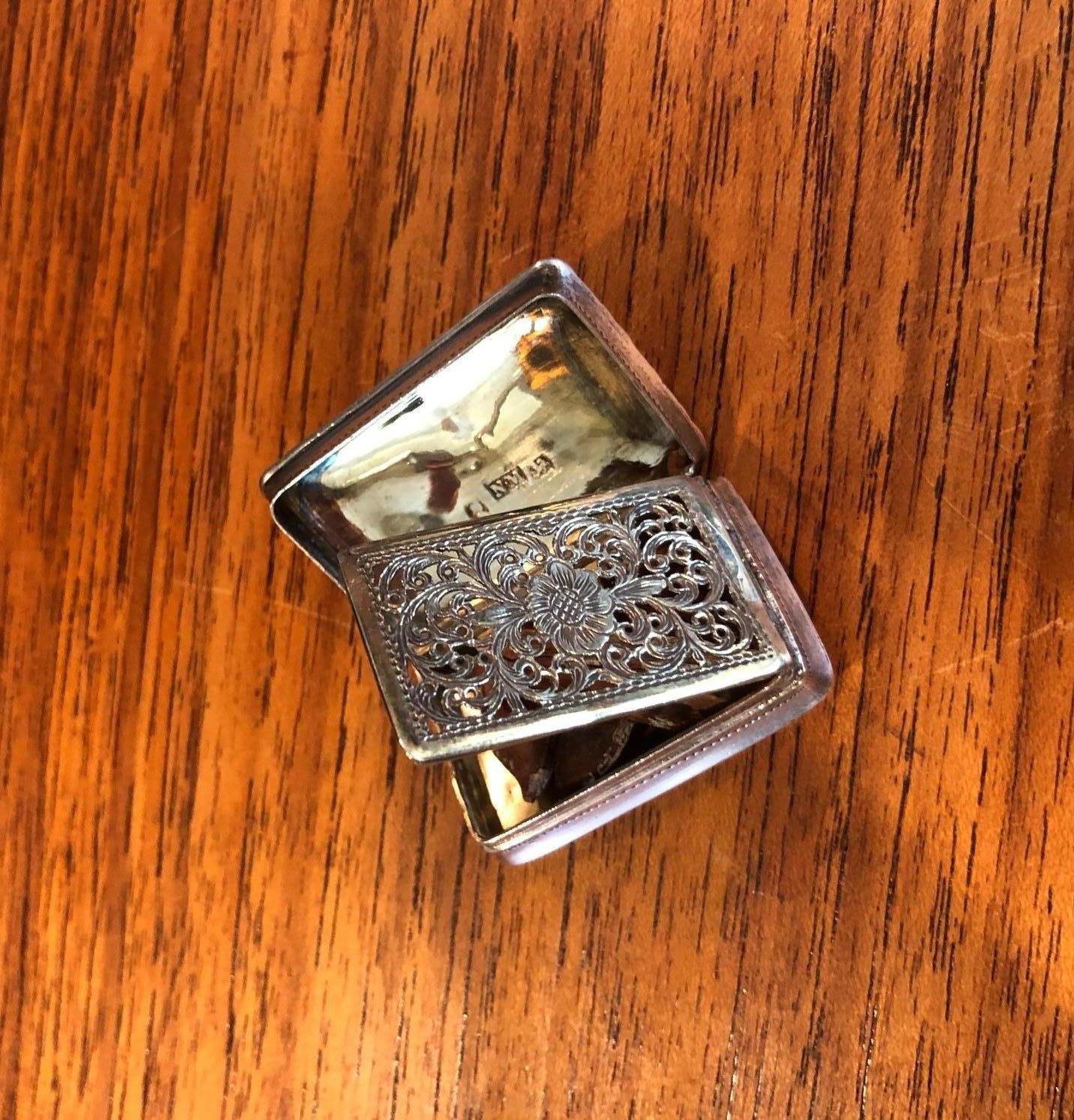 A very rare antique sterling silver viniagrette by silversmith Nathaniel Mills in Birmingham, England, circa 1820s. 

This exceptional antique Georgian silver vinaigrette has a rectangular form with rounded corners; the lid, on a smooth barrel