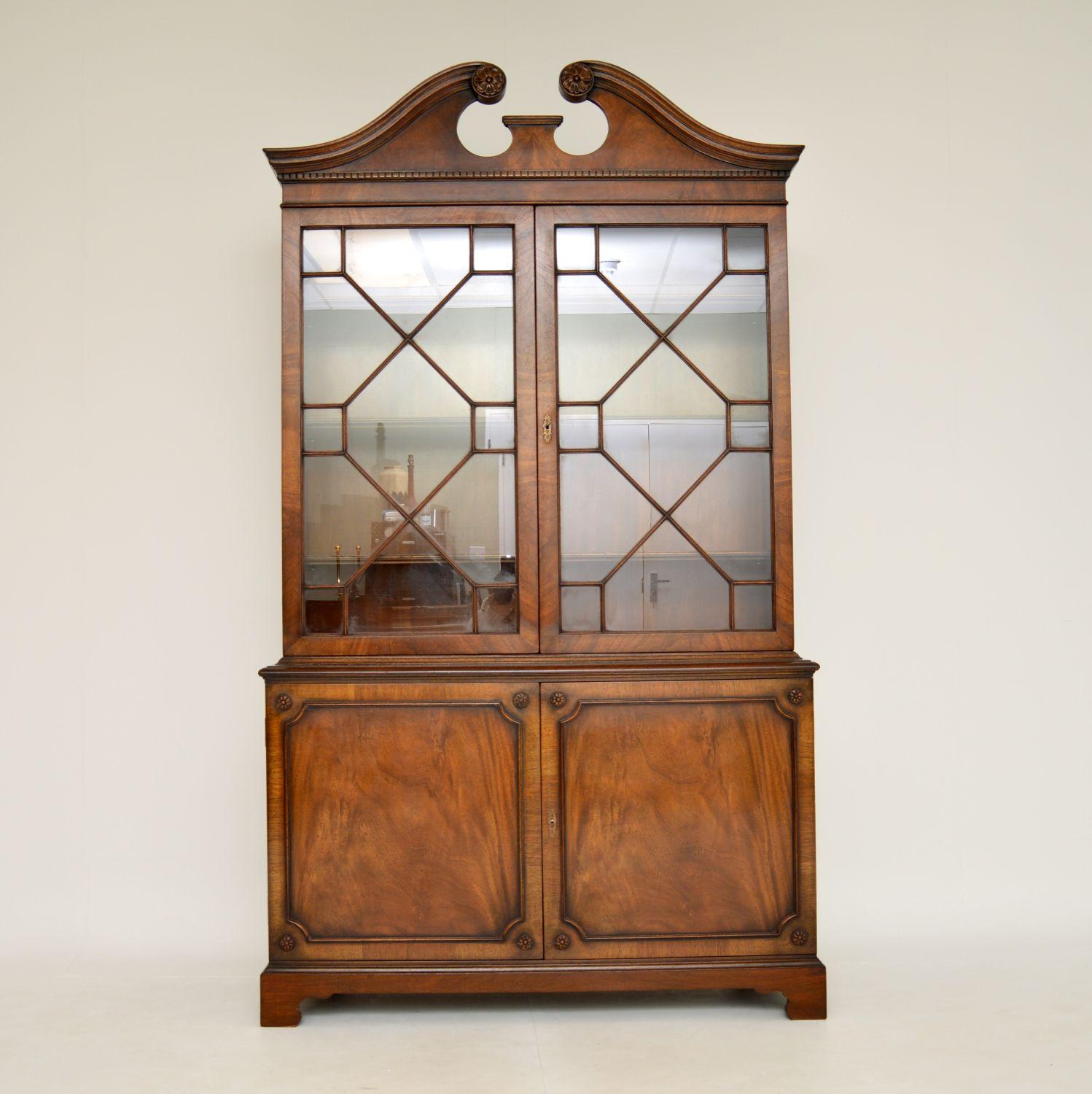 A smart and useful antique Georgian style bookcase. This was made in England, it dates from around the 1930’s period.

The quality is fantastic, the wood has a gorgeous colour tone and lovely grain patterns. The top has a beautifully shaped swan