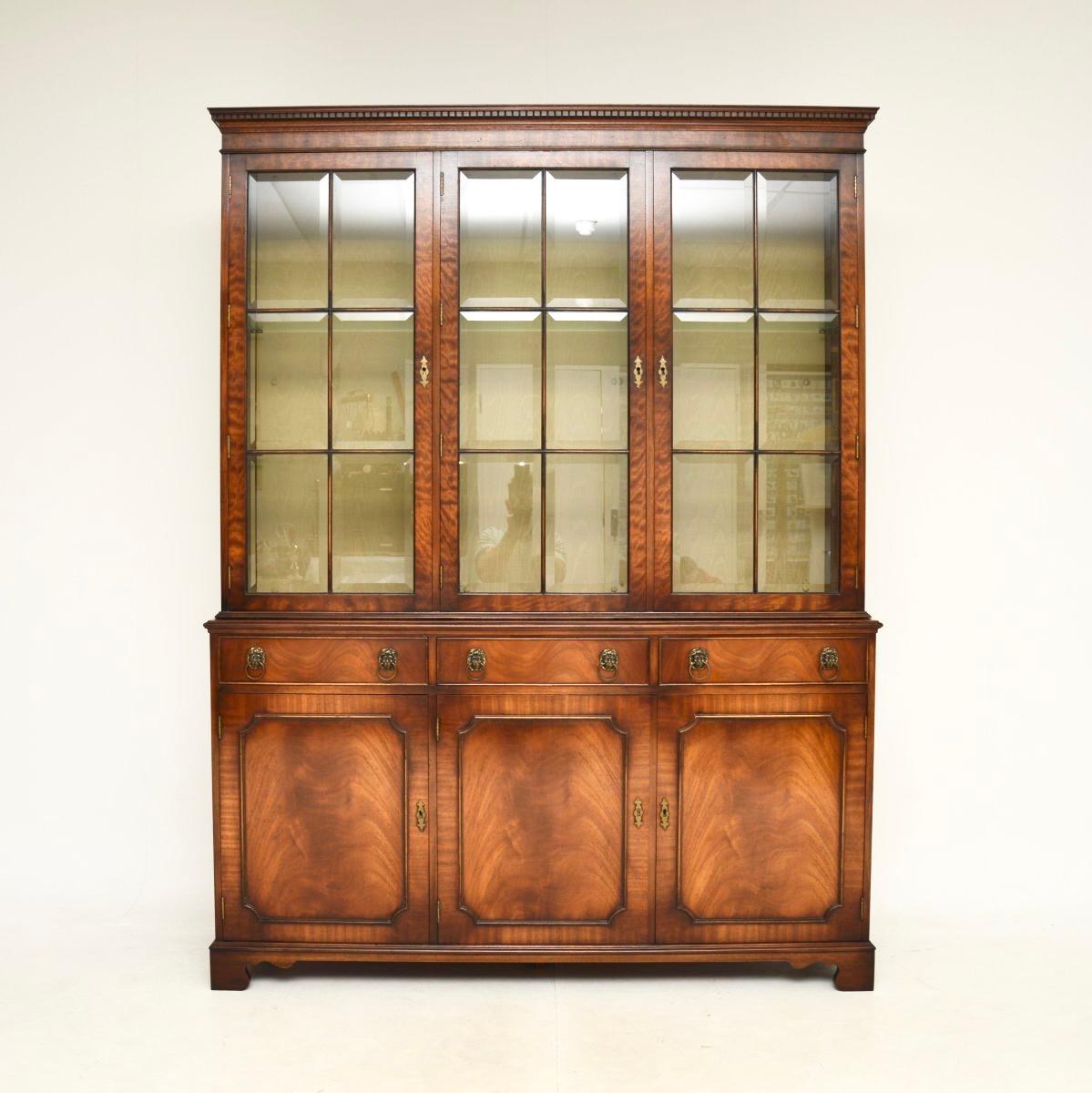 A handsome and top quality large antique Georgian style bookcase. This dates from around the 1950’s.

It is beautifully made, with gorgeous veneers. There is a lovely astral glaze design on the glass door fronts and the glass is even beveled. The