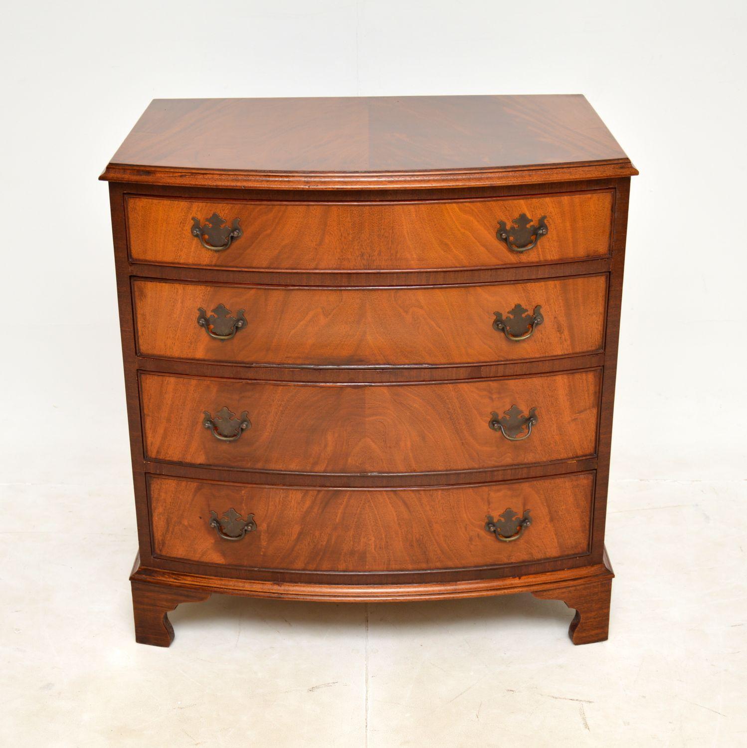 A lovely antique bow fronted chest of drawers in the Georgian style. This was made in England, it dates from around the 1950s.

This is very well made and is a very useful size. There are beautiful flamed grain patterns, this has original brass