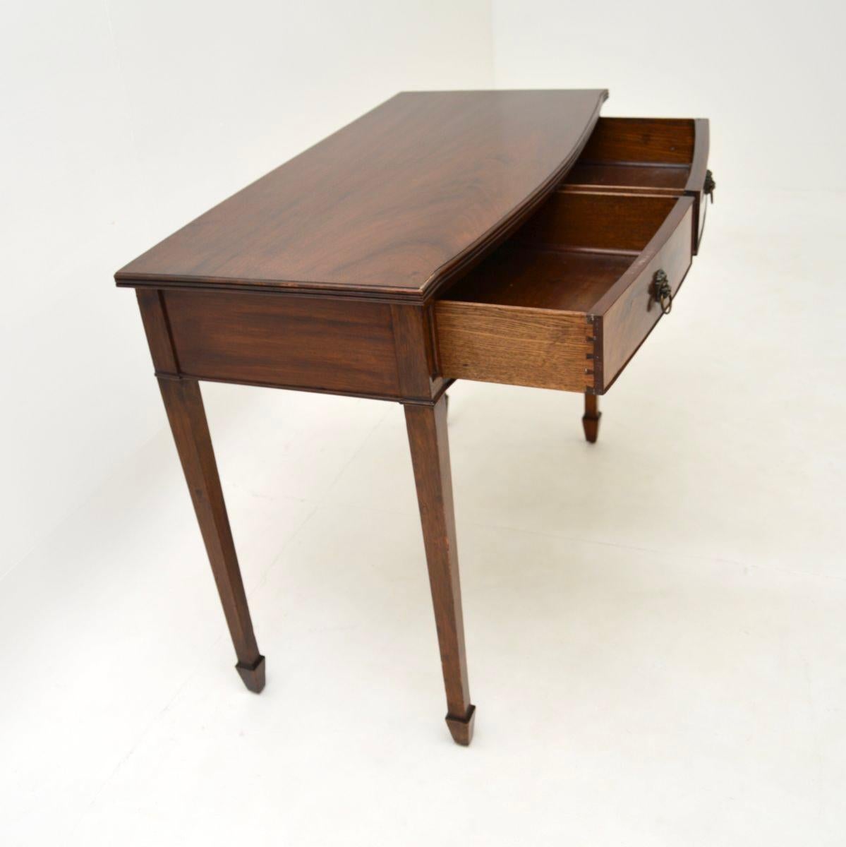 A smart and extremely well made antique bow front console table. It was made in England, it dates from around the 1900-1910 period.

It is of superb quality and has a lovely design, with a bow fronted top standing on tapered legs. There are two