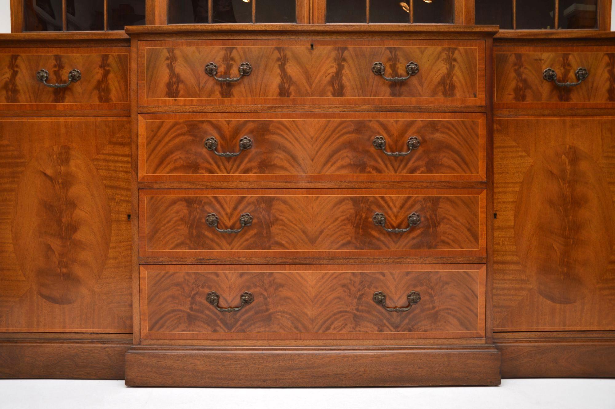 This large very impressive mahogany breakfront secretaire bookcase is antique Georgian style dating from around the 1950s period and it’s of very high quality. Please enlarge all the images to appreciate all the fine details. It has dental moulding
