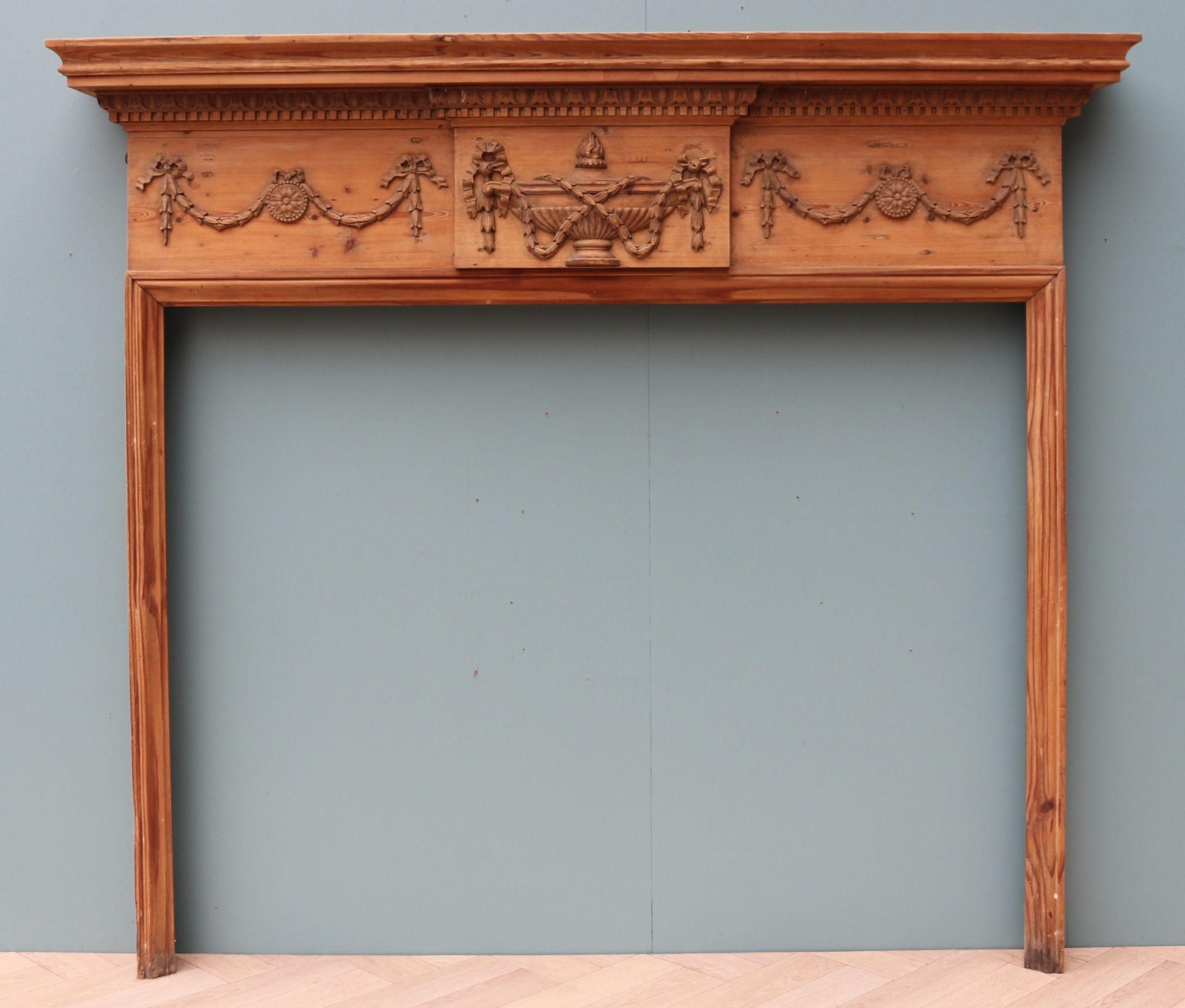 A large surround, currently fitted with Sienna marble slips. These can be removed or replaced with another marble if required. Carved pine urn and swag decoration to the frieze. This fireplace was salvaged from a country house hotel near