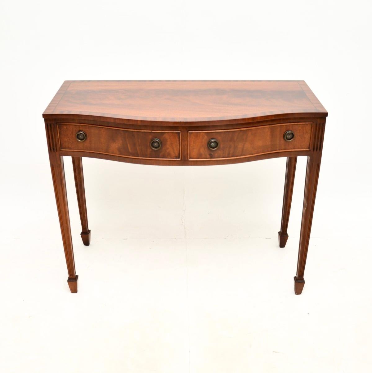 A lovely antique Georgian style console table. This was made in England, it dates from around the 1950’s.

The quality is fantastic, this has a serpentine shaped front with tapered legs terminating in spade feet. The drawers are felt lined and have