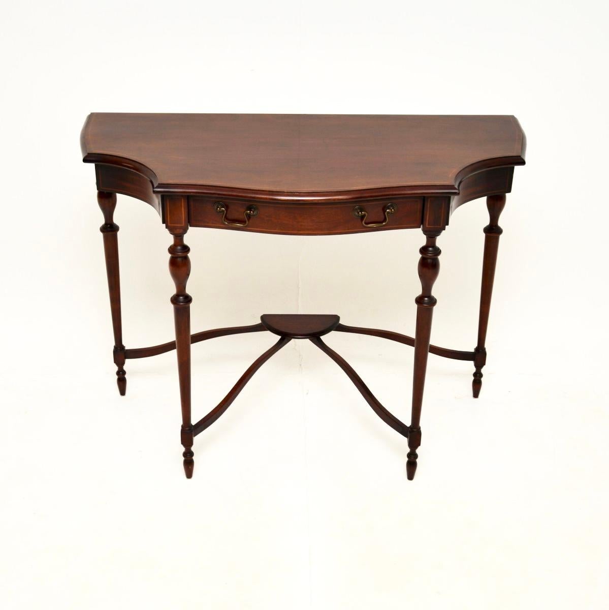 A beautiful and elegant antique Georgian style console table. This was made in England, it dates from around the 1950’s.

The quality is lovely, this sits on finely turned legs and has a gorgeous serpentine shaped front. There is satinwood inlay