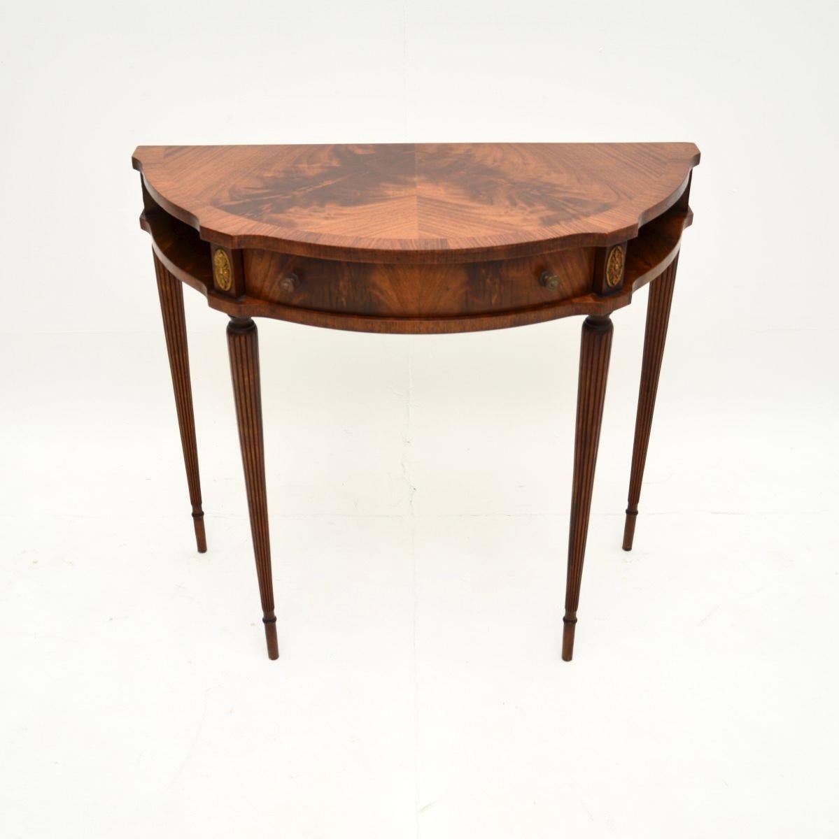A beautiful and elegant antique Georgian style console table. This was made in England, it dates from around the 1950’s period.

The quality is excellent and this has a lovely, compact and stylish design. The front has a serpentine shape, it sits on