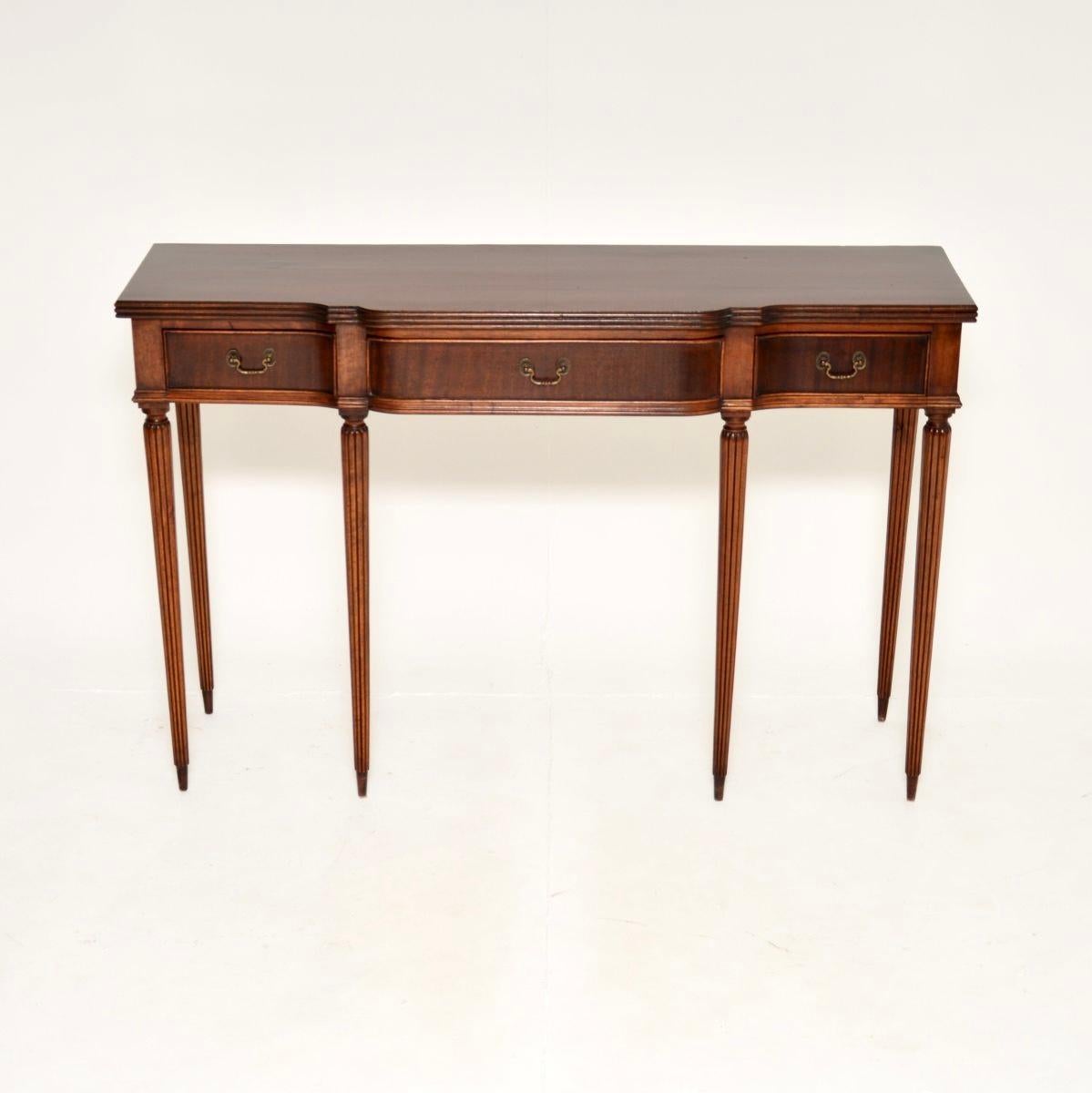 Un delizioso tavolo consolle antico in stile georgiano, realizzato in Inghilterra e risalente agli anni '50 circa.

È di ottima qualità e di dimensioni molto utili, con un utile spazio di archiviazione nei tre cassetti. Ha una bella forma a