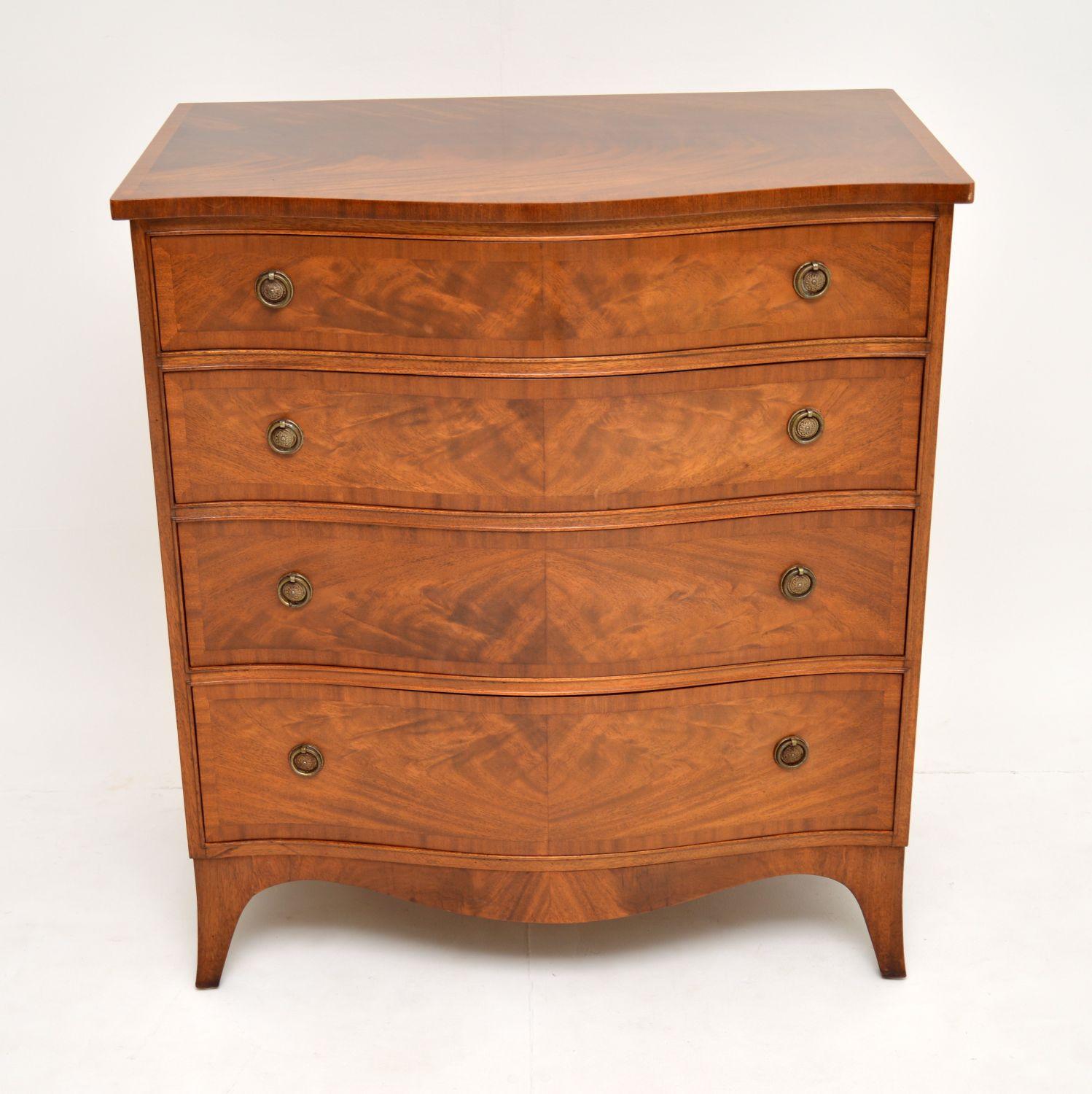 A beautifully made serpentine front chest of drawers, in the antique Georgian style. This dates from circa 1930s-1950s, it’s of excellent quality.

The top and drawer fronts are cross banded. The drawers are graduated in depth and have the