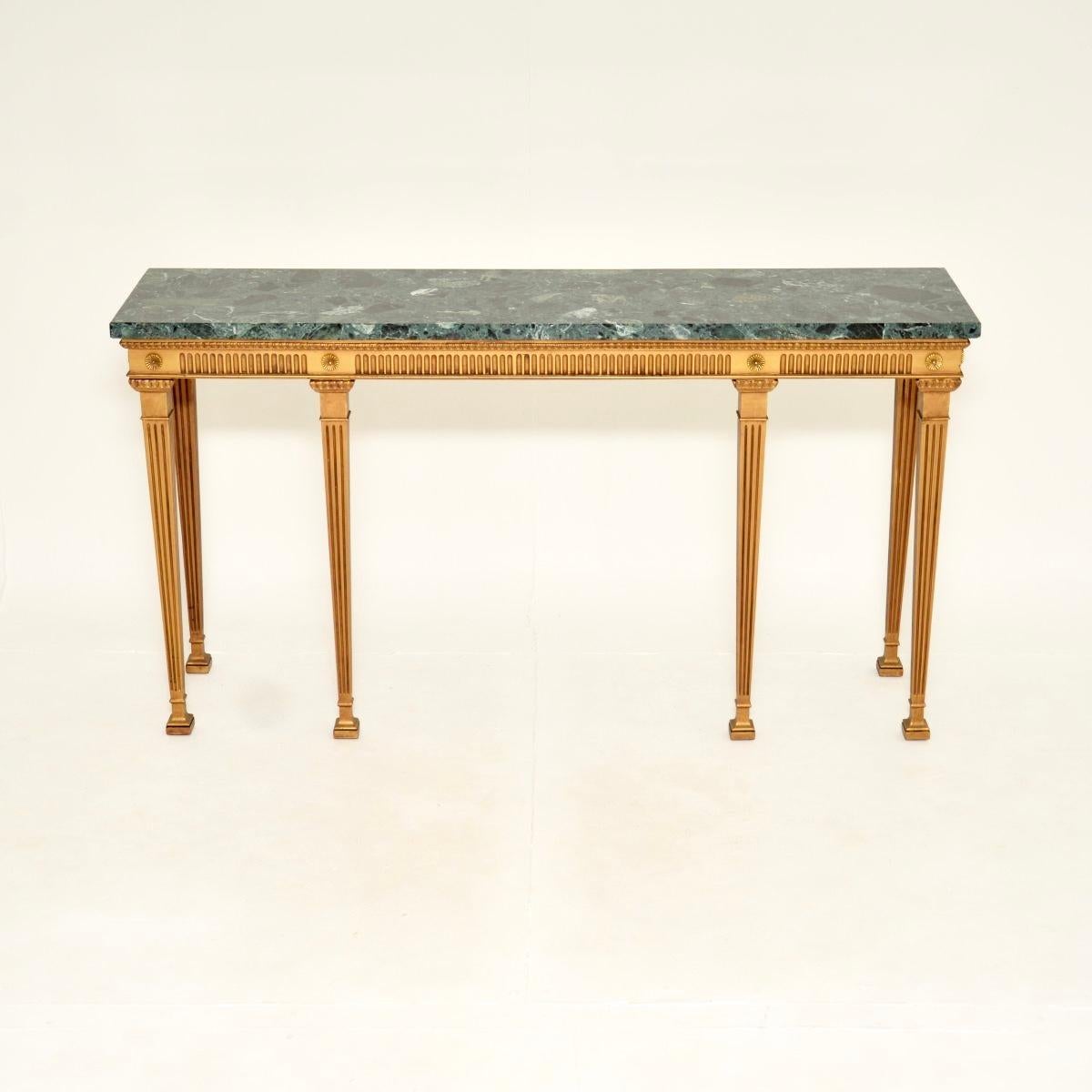 A large and impressive antique Georgian style gilt wood marble top console table. This was made in England, it dates from around the 1930’s.

It has a stunning design, the gilt wood frame has grooved edges, rosettes at the top corners, it stands on
