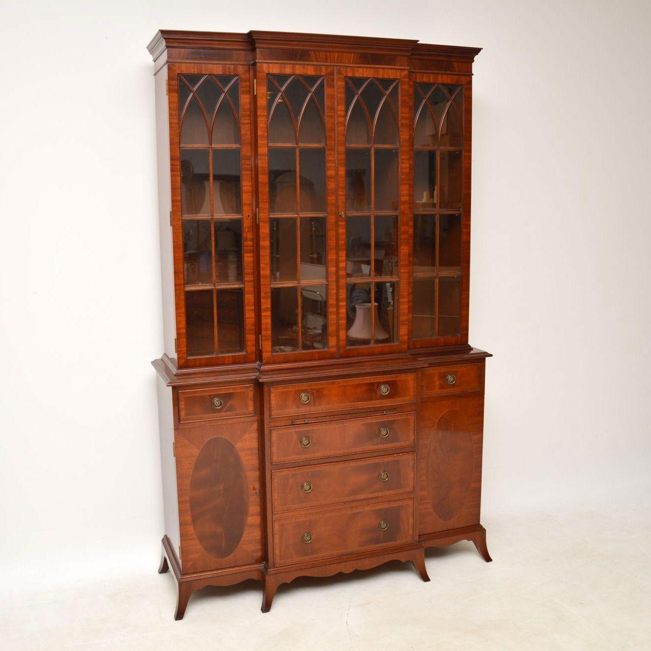 Antique George III style mahogany breakfront bookcase of very high quality, with smallish proportions and with some lovely features. I would say this bookcase is about 40-50 years old. The top section has four Gothic style astral glazed doors and