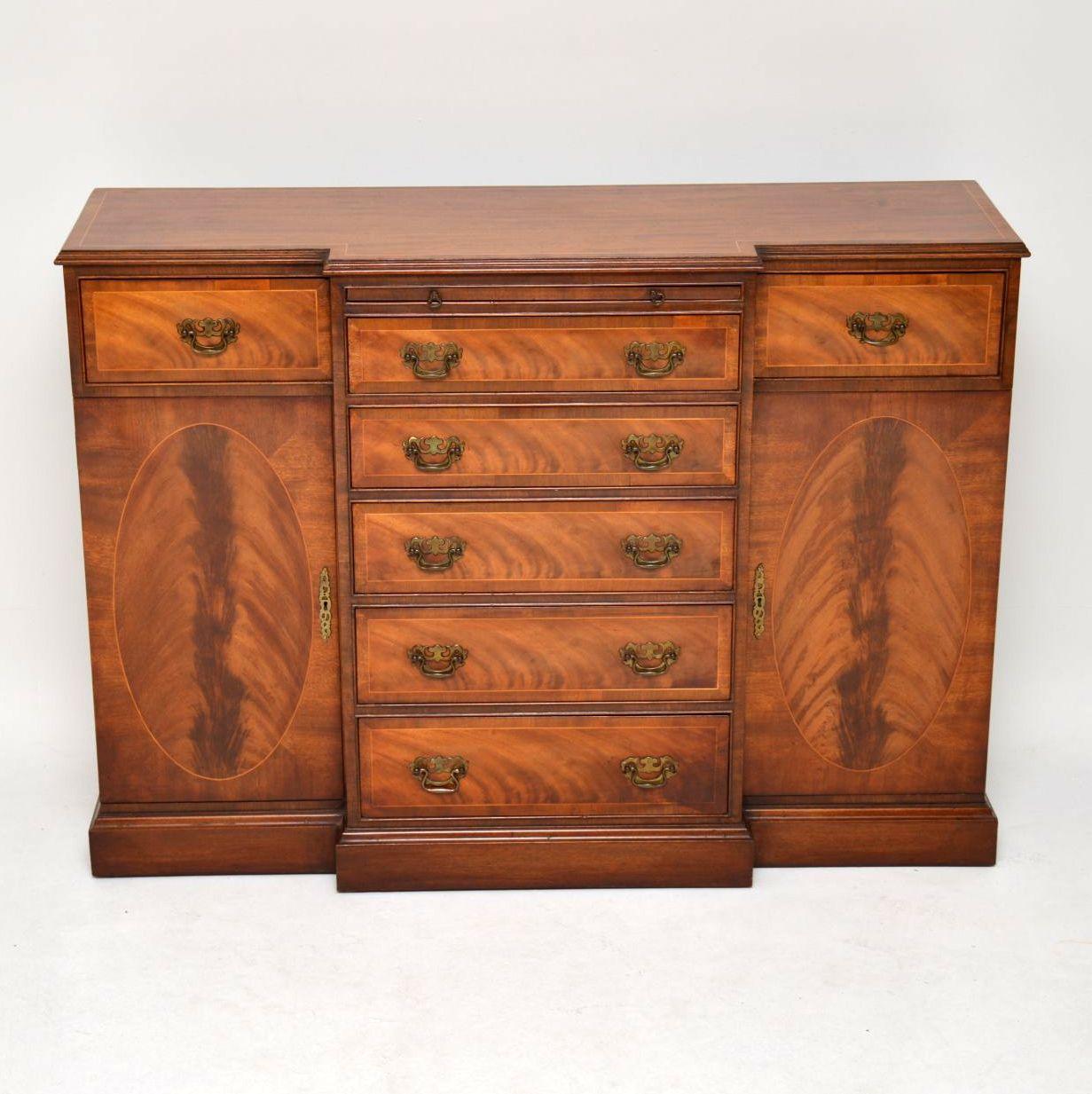 This is an antique Georgian style breakfront mahogany sideboard dating from around the 1950’s period & with some very fine features. The top has satinwood inlay with cross banding outside of that. The inlays & crossbandings are repeated on all the
