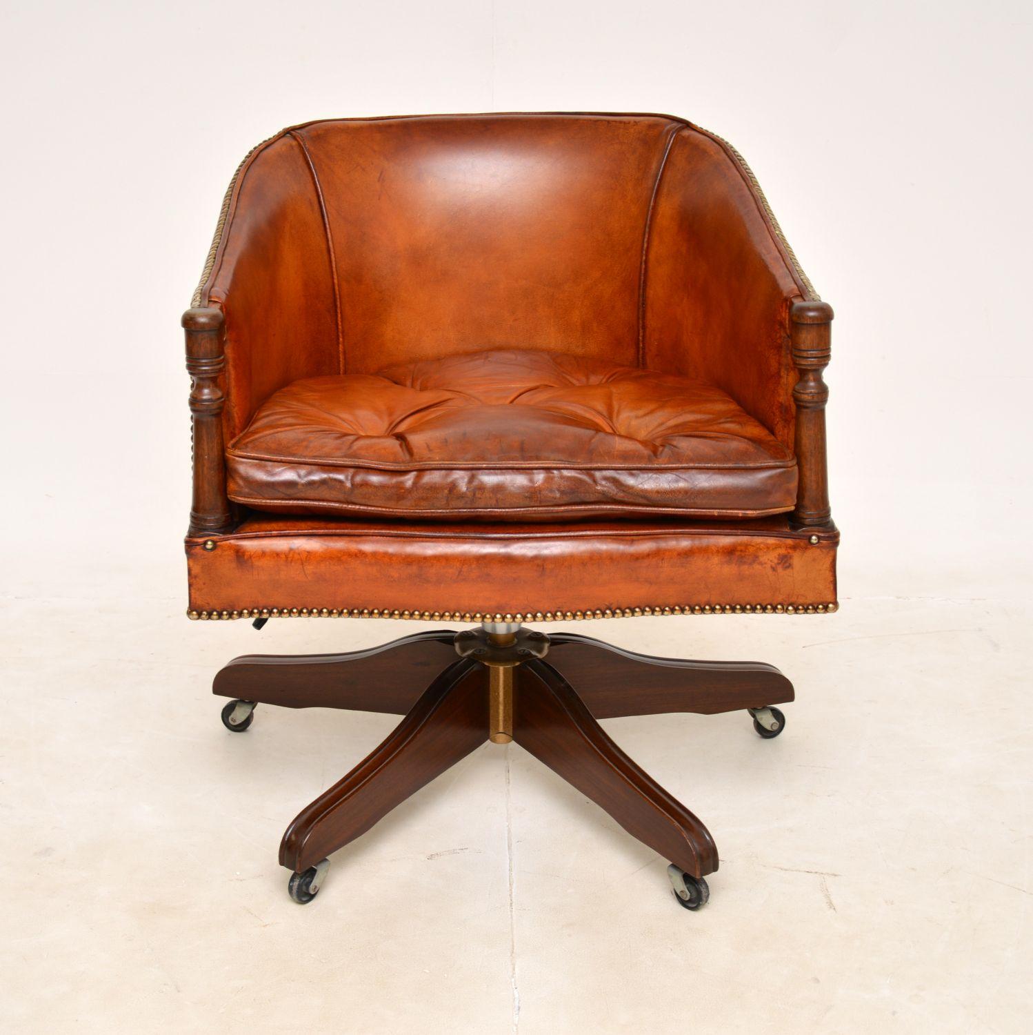 A smart and very well made antique leather swivel desk chair in the Georgian style. This was made in England, it dates from around the 1950-1960s.

It is of fantastic quality and is very comfortable. The tub shaped frame has studded leather, it