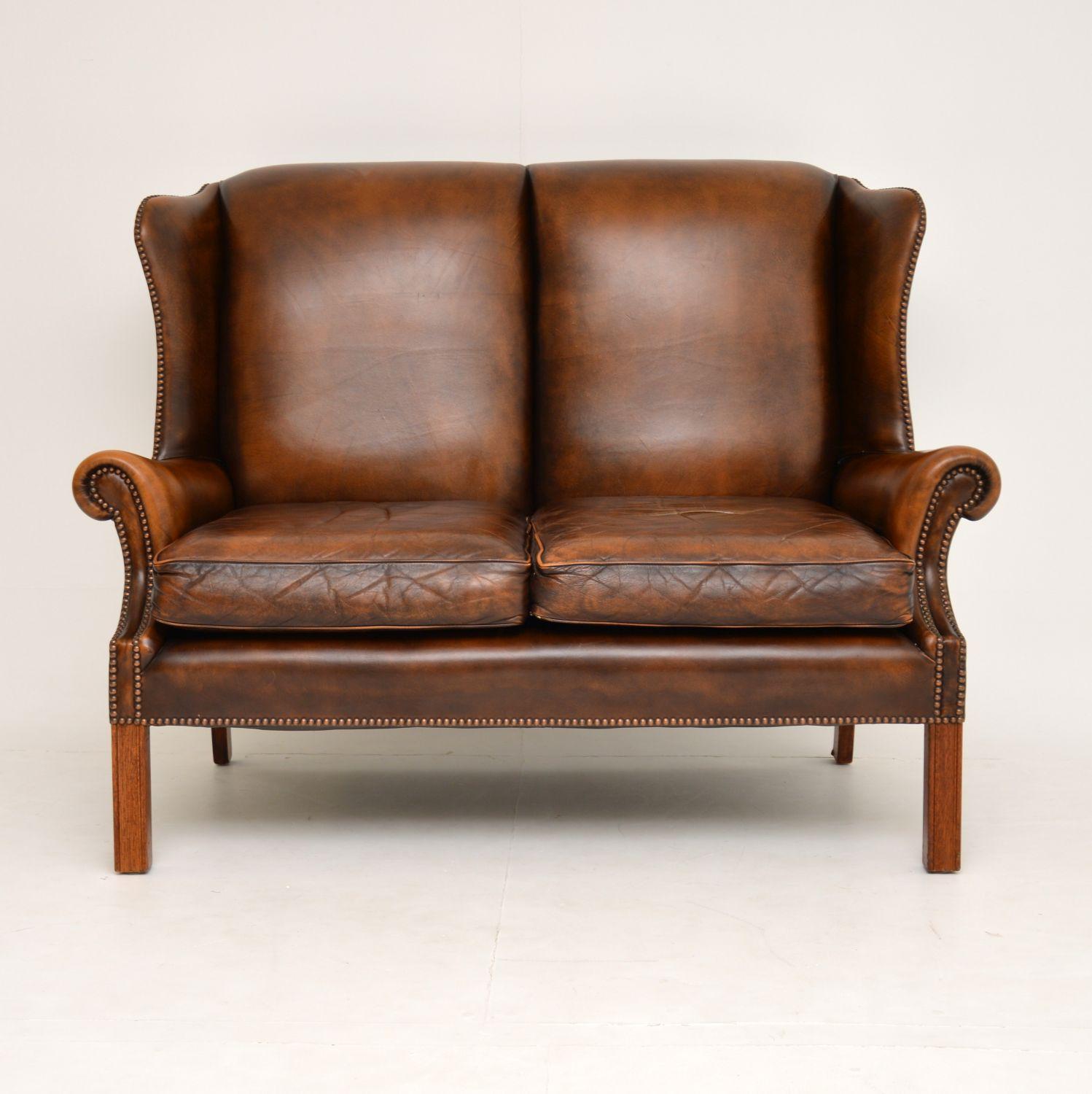 Very comfortable antique Georgian style two seater wing back sofa in good original condition & dating from around the 1960’s period.

The colour of the leather has naturally worn & faded with use. However – There are no tears, splits or holes &