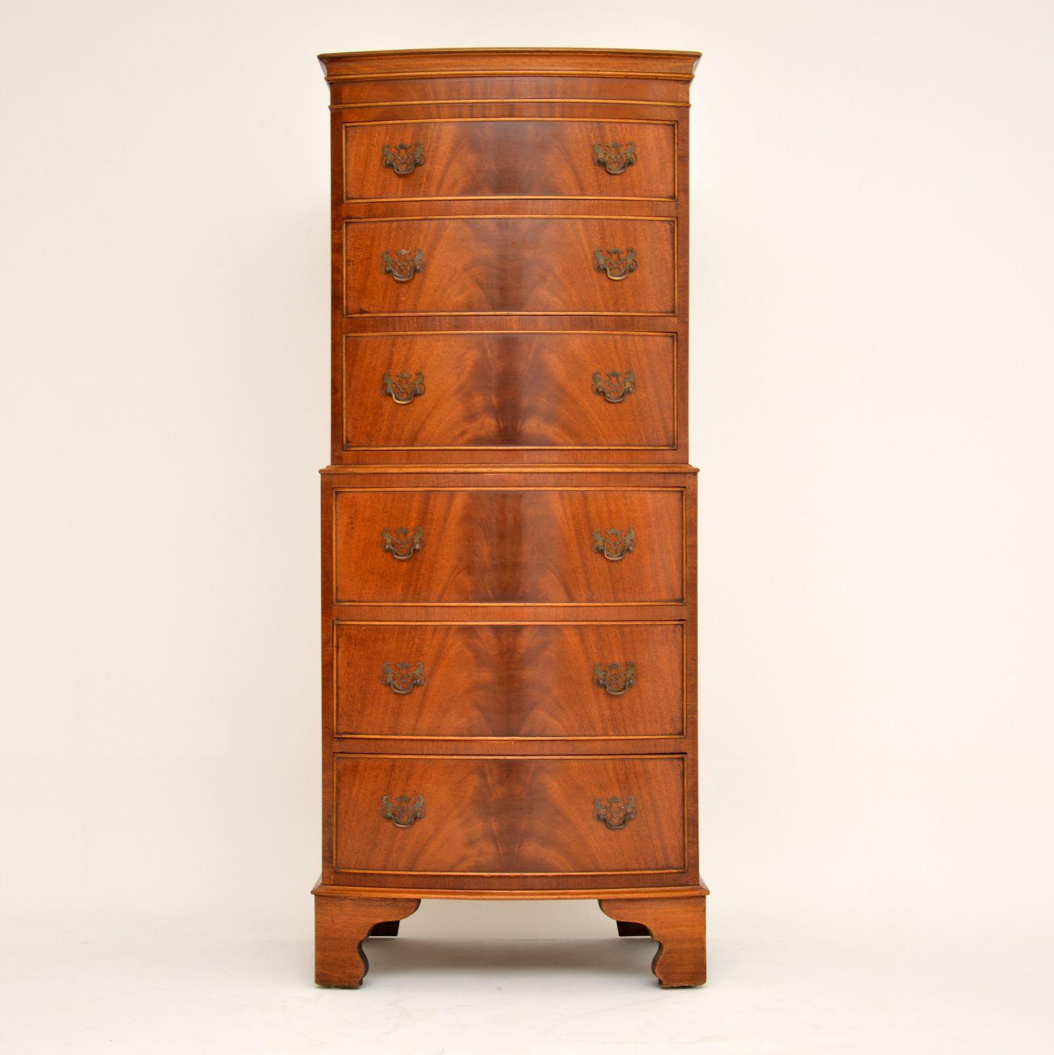 Slim antique Georgian style mahogany chest on chest in excellent condition and dating from the 1930s-1950s period. The flame mahogany drawers are graduated in depth and have original brass handles. This chest of drawers is bow fronted & sits on