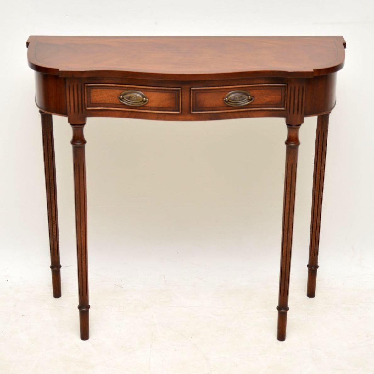 This antique style mahogany console side table is really slim from back to front & quite small in proportions. This table has a serpentine shaped front. The flame mahogany top is cross banded with fine ebony inlay in-between & the drawers are the