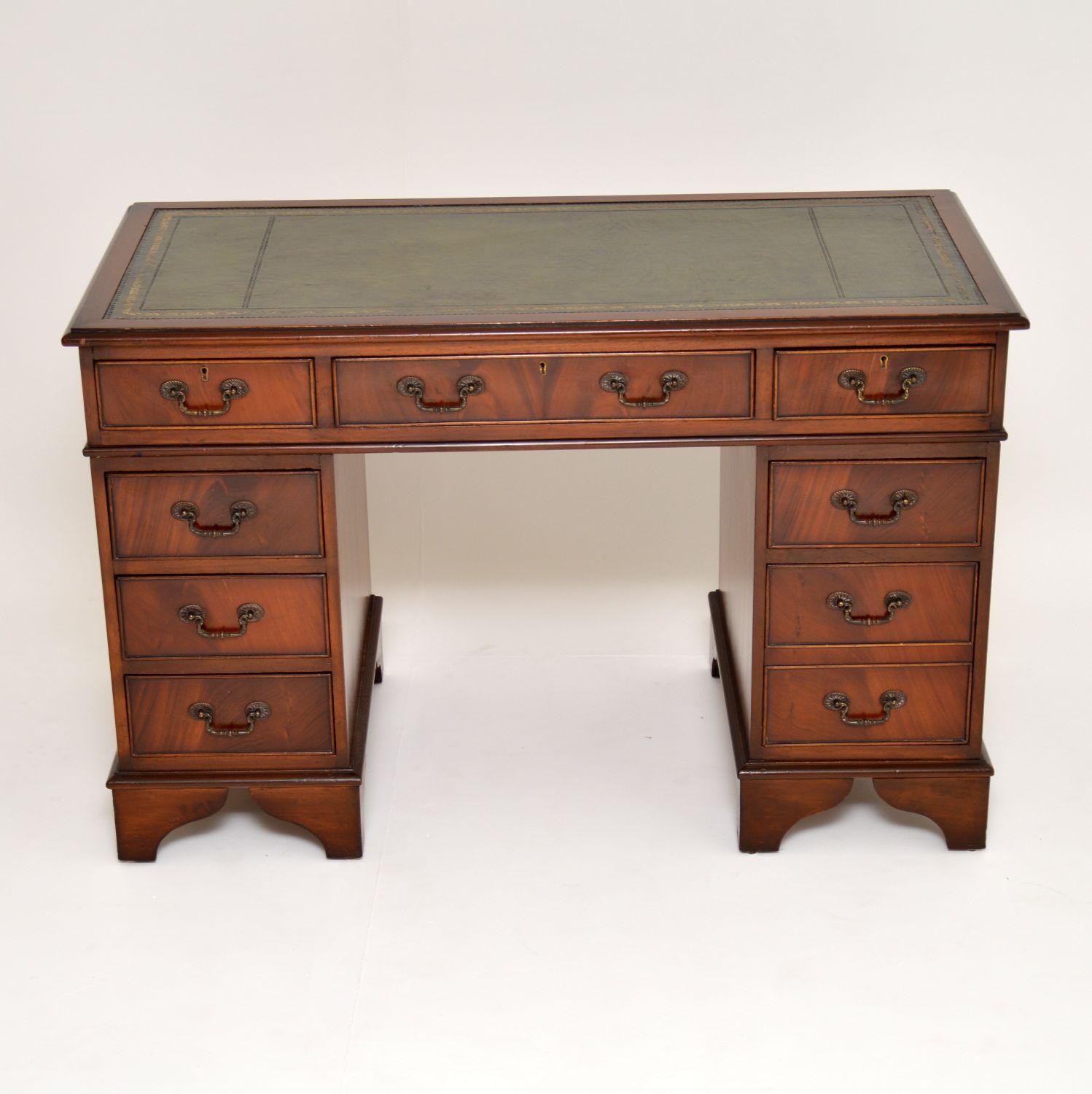 Antique Georgian style mahogany leather top pedestal desk in very good original condition and dating to circa 1950s period. This is a very well constructed desk that separates into three sections for easy transportation. It has a hand gold tooled