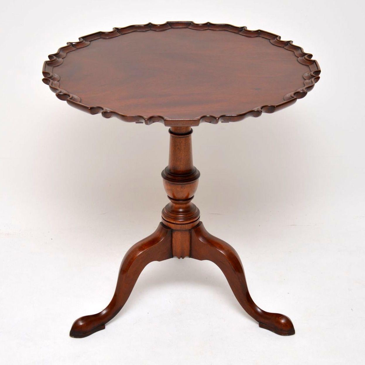 Fine quality antique George III style solid mahogany tilt-top table in lovely condition and dating to circa 1950s period. It has a solid mahogany top, a shaped pie crust edge and sits on a well turned baluster pedestal on tripod pad feet. The turned