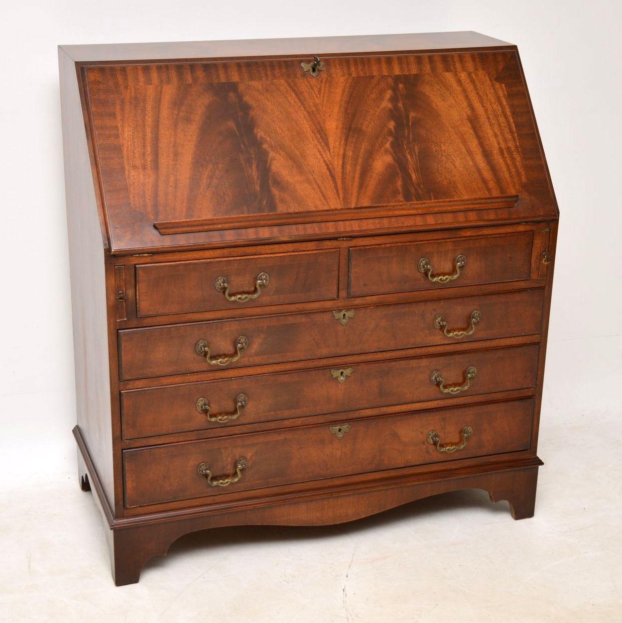 This antique Georgian style mahogany bureau has a lovely detailed writing compartment and the unusual feature of a bar across the slope to support paper sheets or something else. It’s in good condition and I would date it to the 1950s period. The