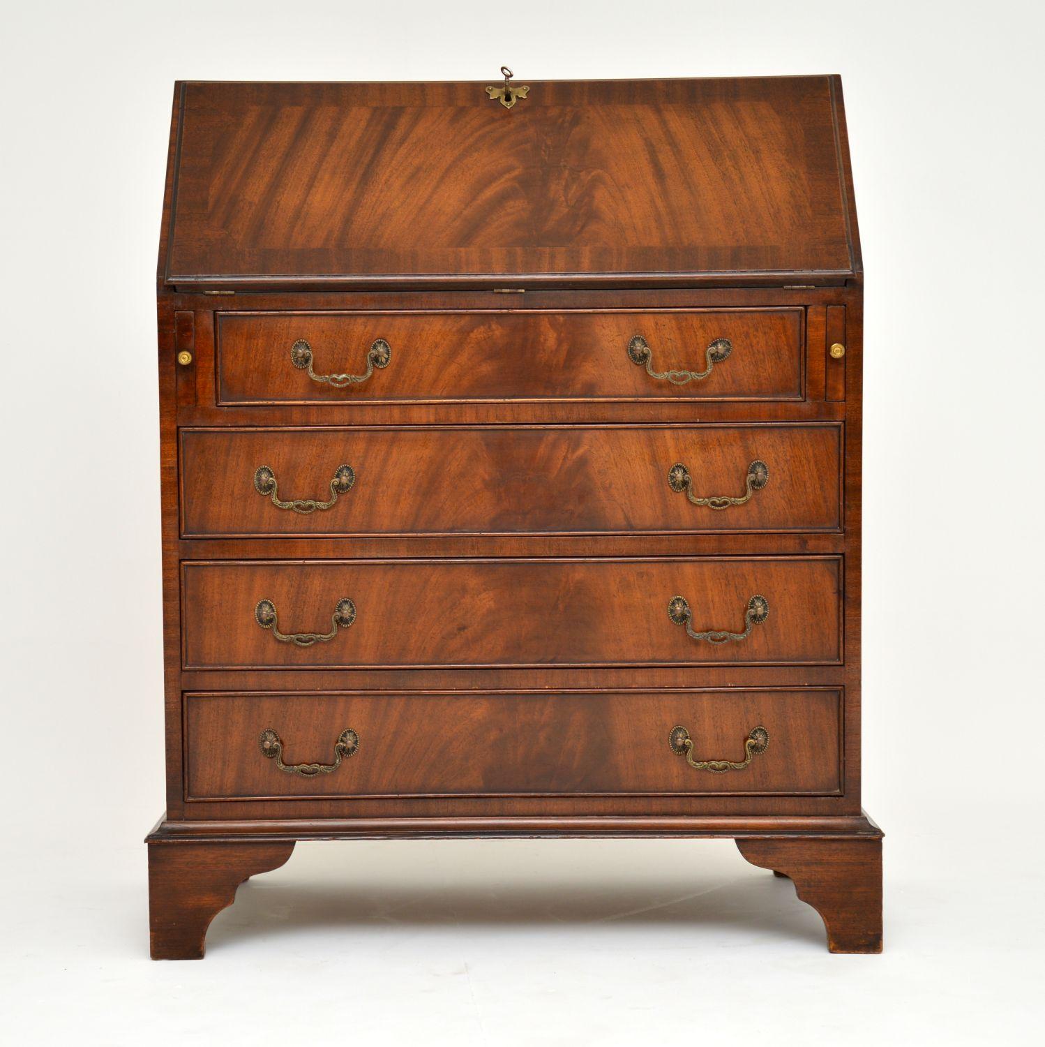 Antique Georgian style mahogany bureau which is nice and compact with four drawers on bracket feet. It has a busy interior, with small drawers, compartments, a central cupboard and a tooled leather writing surface. The top and the bureau flap are