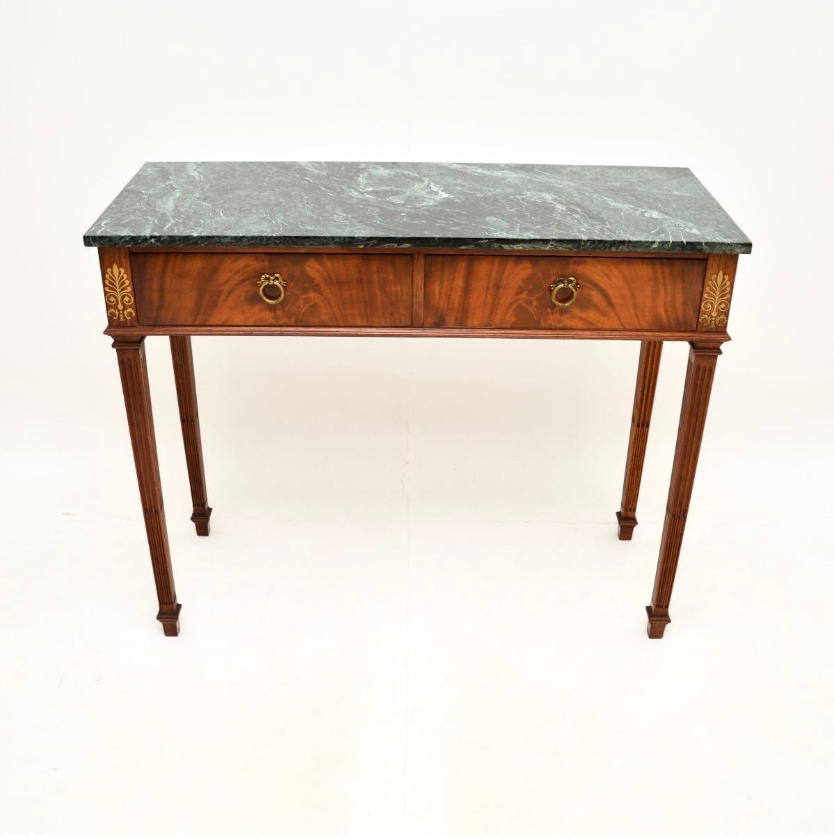 A wonderful antique marble top console table. This was made in England, it dates from around the 1900-1910 period.

It is of extremely fine quality, the brass inlaid patterns are crisp and beautifully executed. The drawers have lovely brass handles,