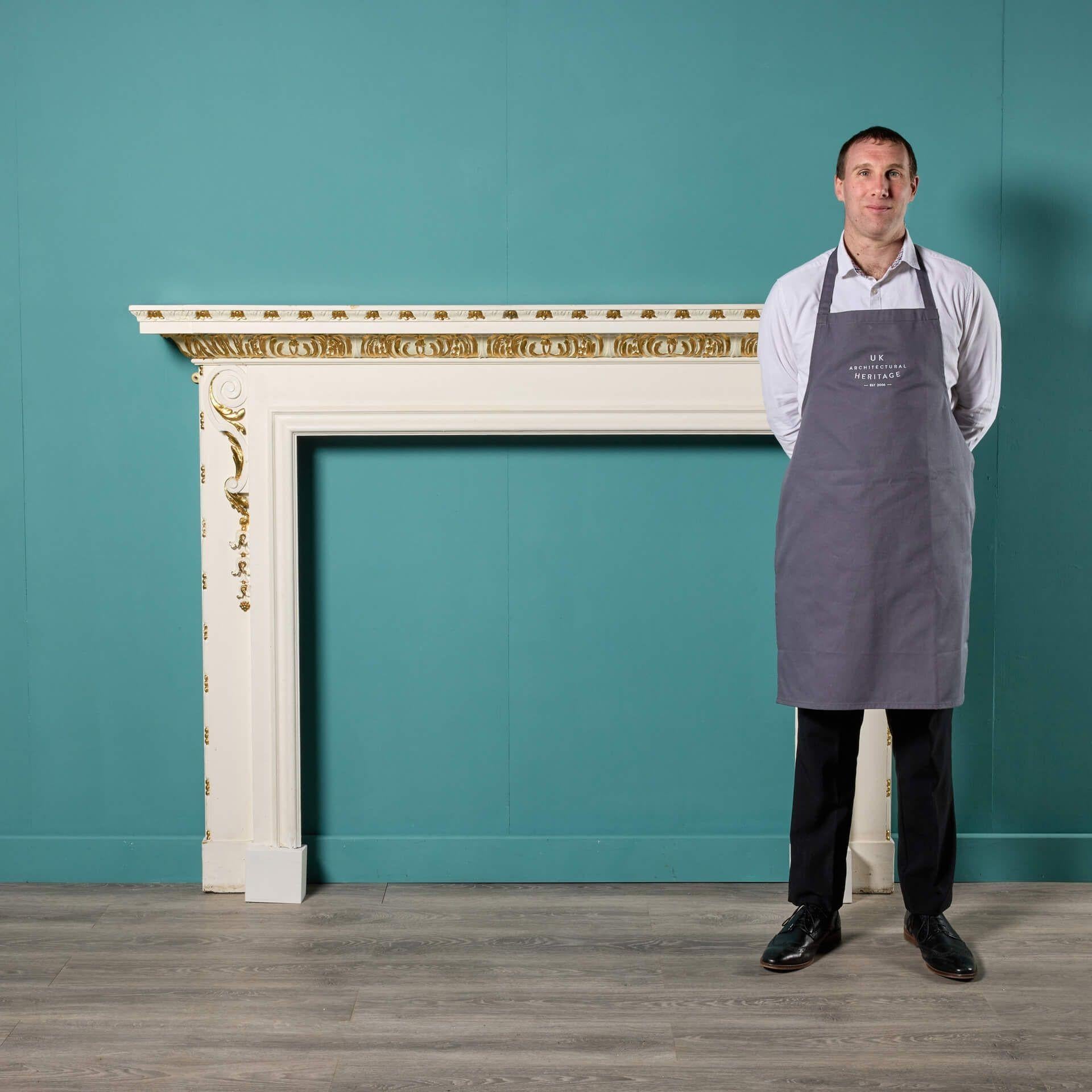 An antique Georgian style painted pine fireplace, sourced from a £13 million house in Hampstead, London.

Painted with gold leaf beneath the mantel and scrolls decorating the jambs, this late 19th century fire surround is an ode to classic Georgian