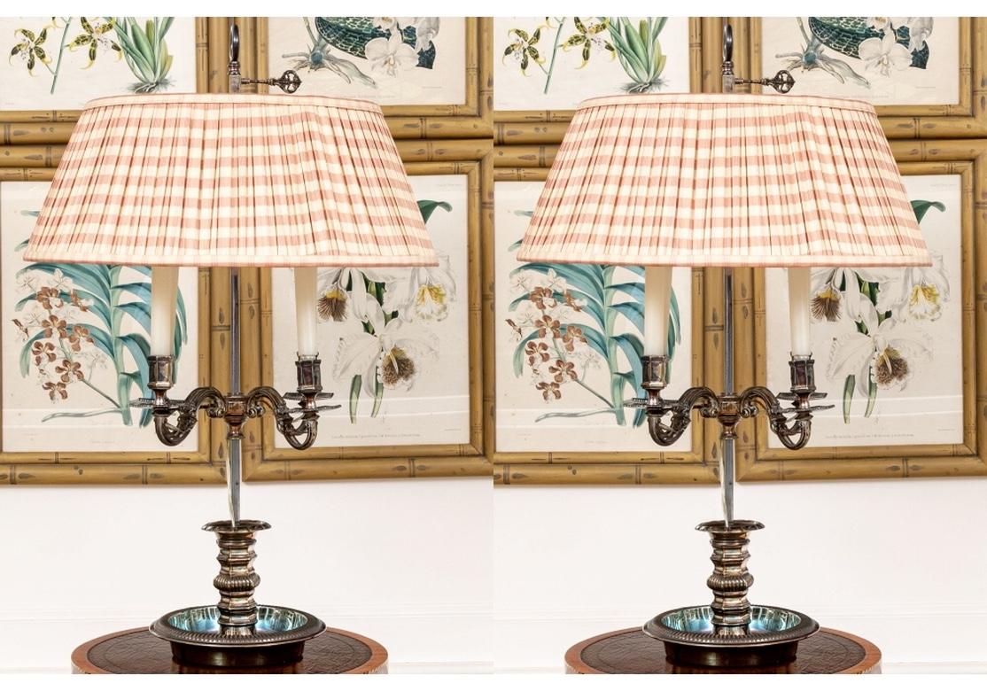 Very fine and rare pair of antique silvered bronze bouillotte style lamps with four lights, originally crafted as candelabras and since electrified with visible wiring. The four scrolled lights mounted on a faceted support on a dish base. Adjustable