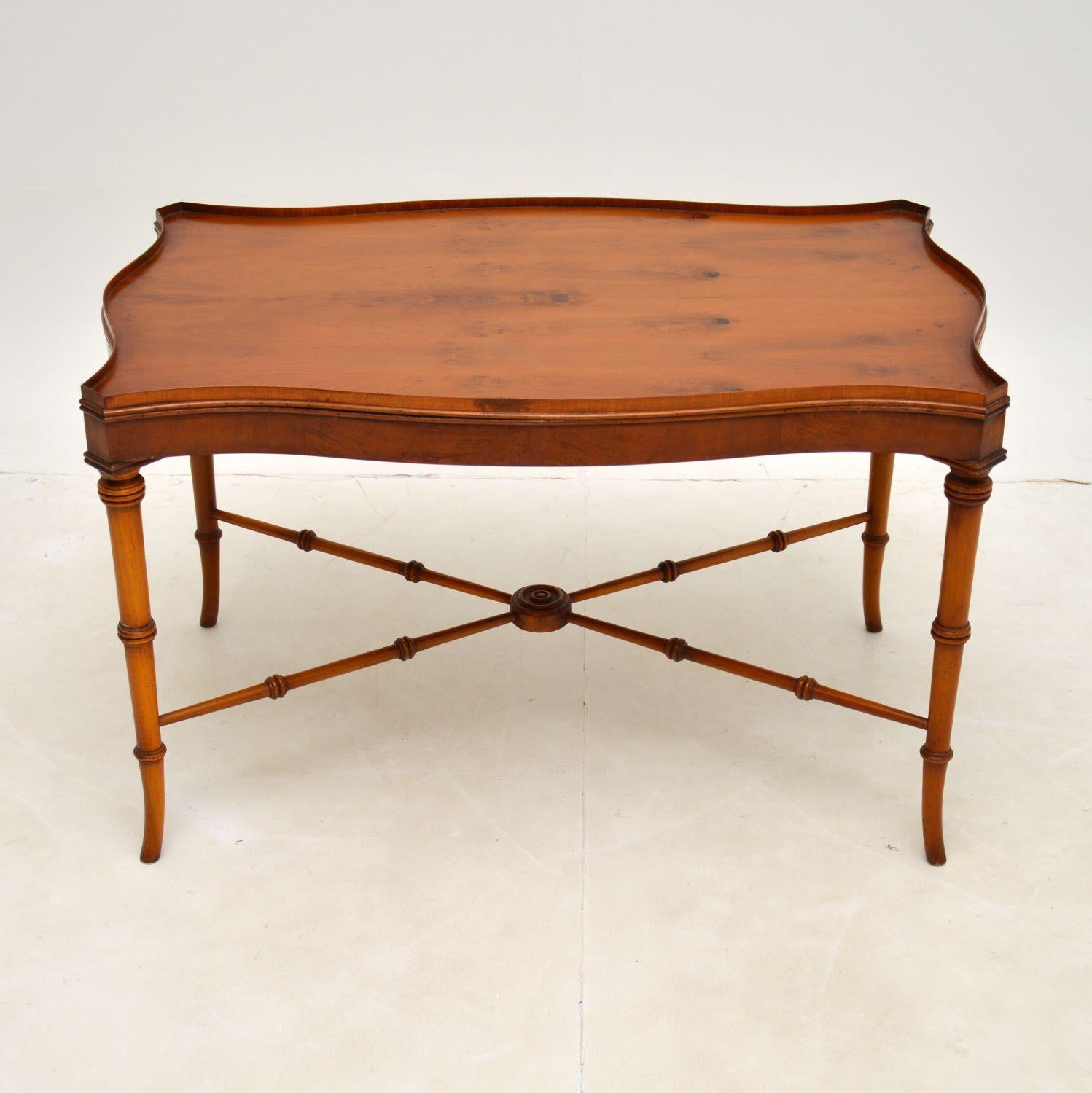 A beautiful and elegant Yew Wood coffee table in the antique Georgian style. This was made in England, it dates from around the 1930-50’s.

This is of fine quality and is a lovely size. The serpentine shaped top has a lipped edge, the cross