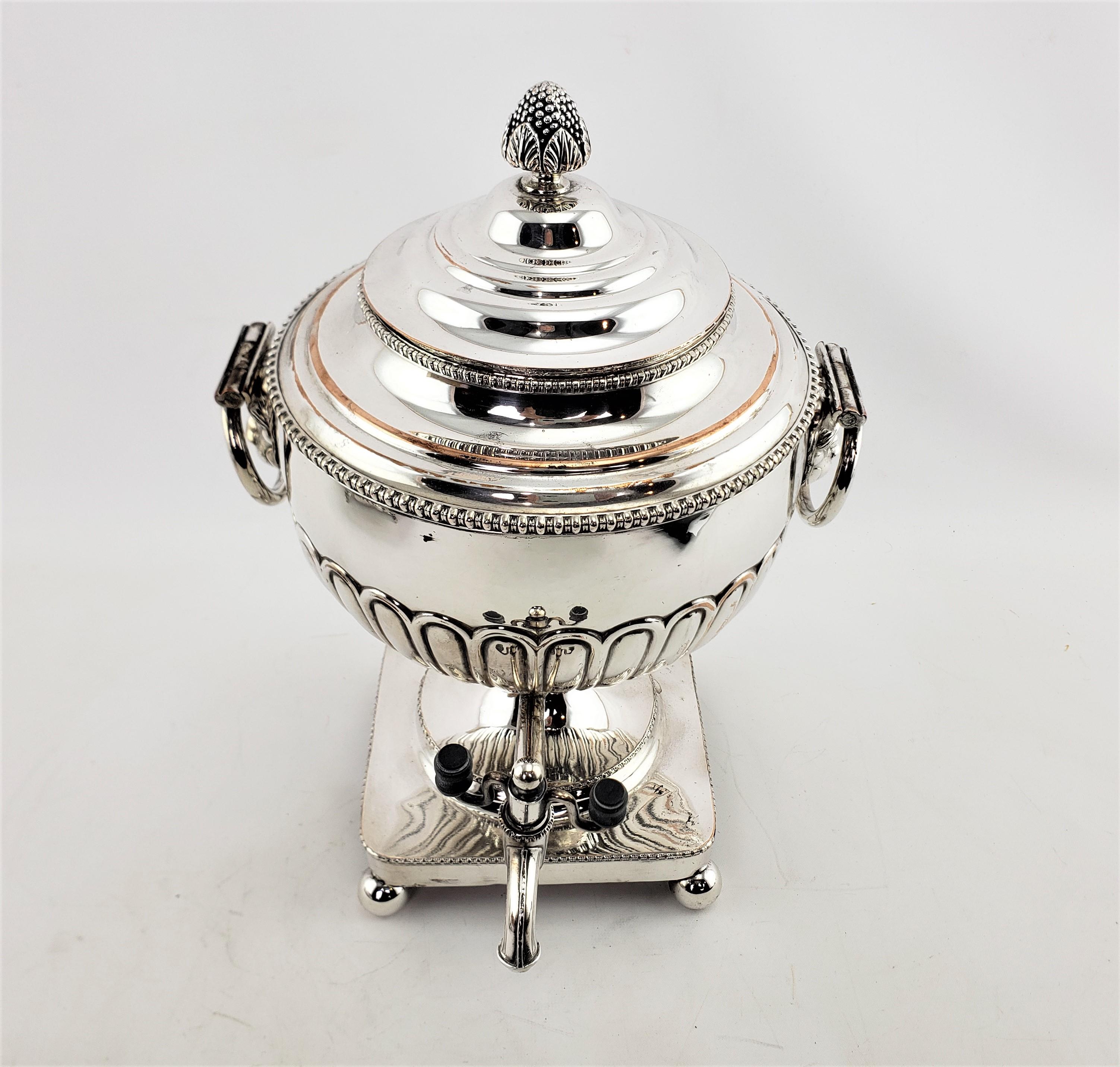 This antique hot water urn or server is unsigned, but presumed to have originated from England and date to approximately 1880 and done in a Georgian style. This urn is composed of copper with a silver plated finish with tapered sides and raised