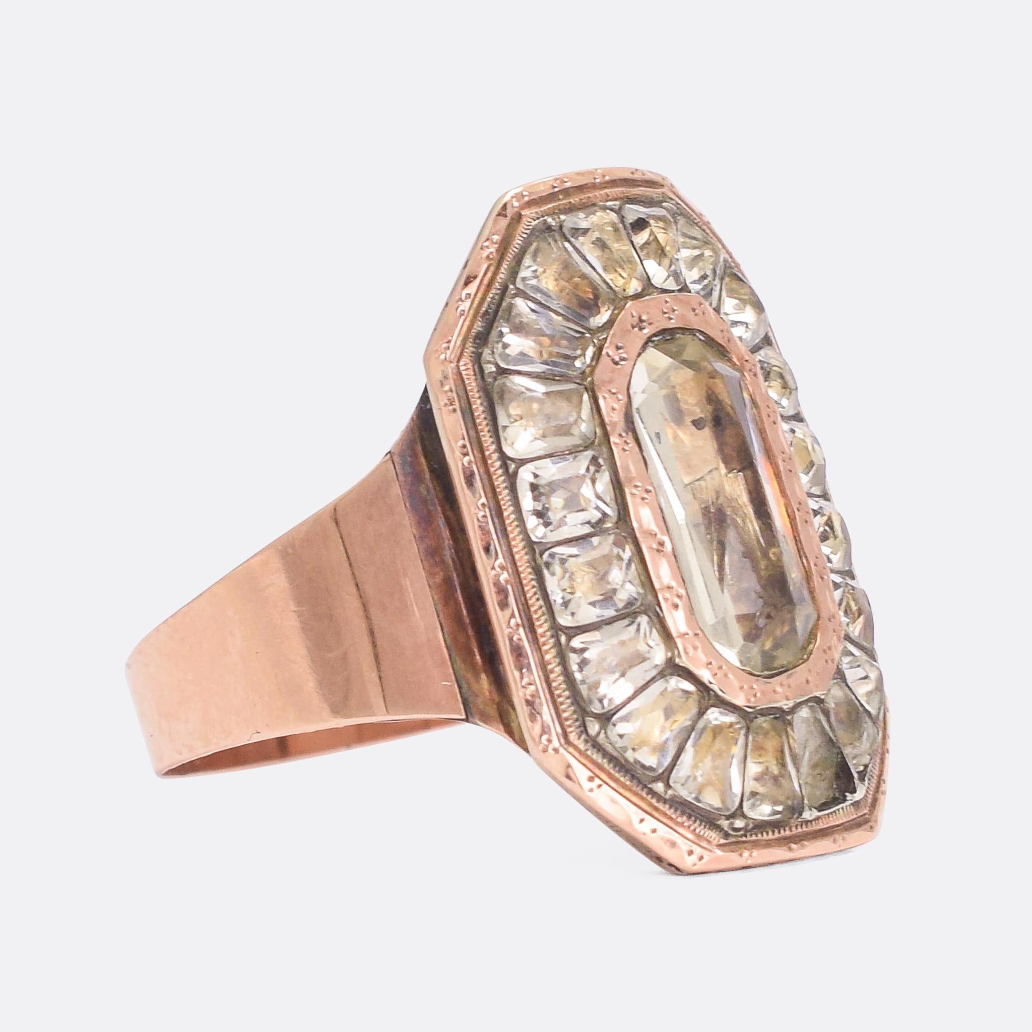 A spectacular Georgian cluster ring set with lively white paste stones arranged on a long octagonal head. The stones are foil-backed, and show a surprising range of colour in the facets. Modelled in 15 karat rose gold, it's a substantial size and
