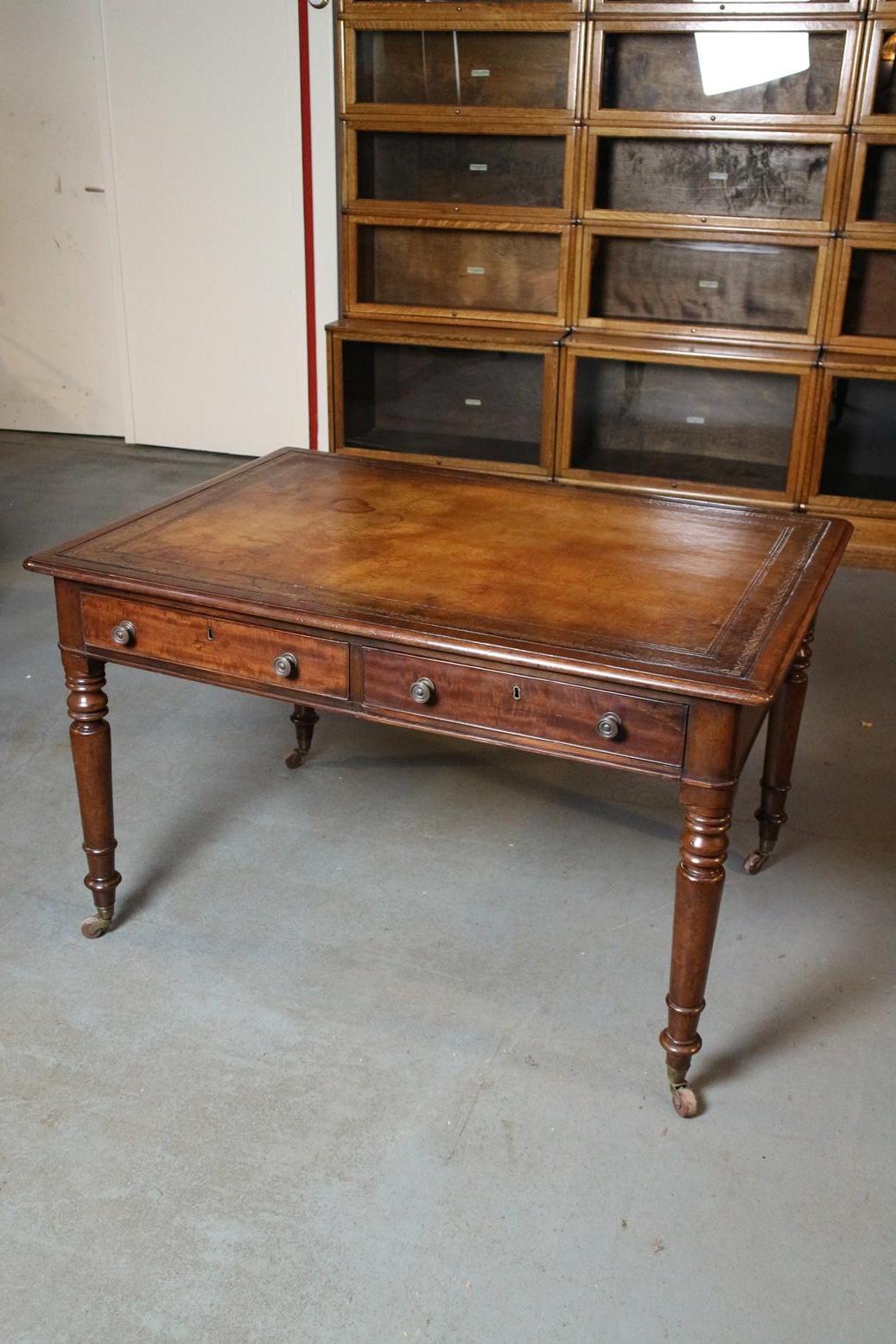 Table à écrire géorgienne ancienne en acajou. La table est recouverte d'un magnifique cuir brun patiné. Il s'agit d'une capote en cuir de vachette. Le cuir de mouton est souvent utilisé. L'avantage du cuir de vachette est qu'il est beaucoup plus