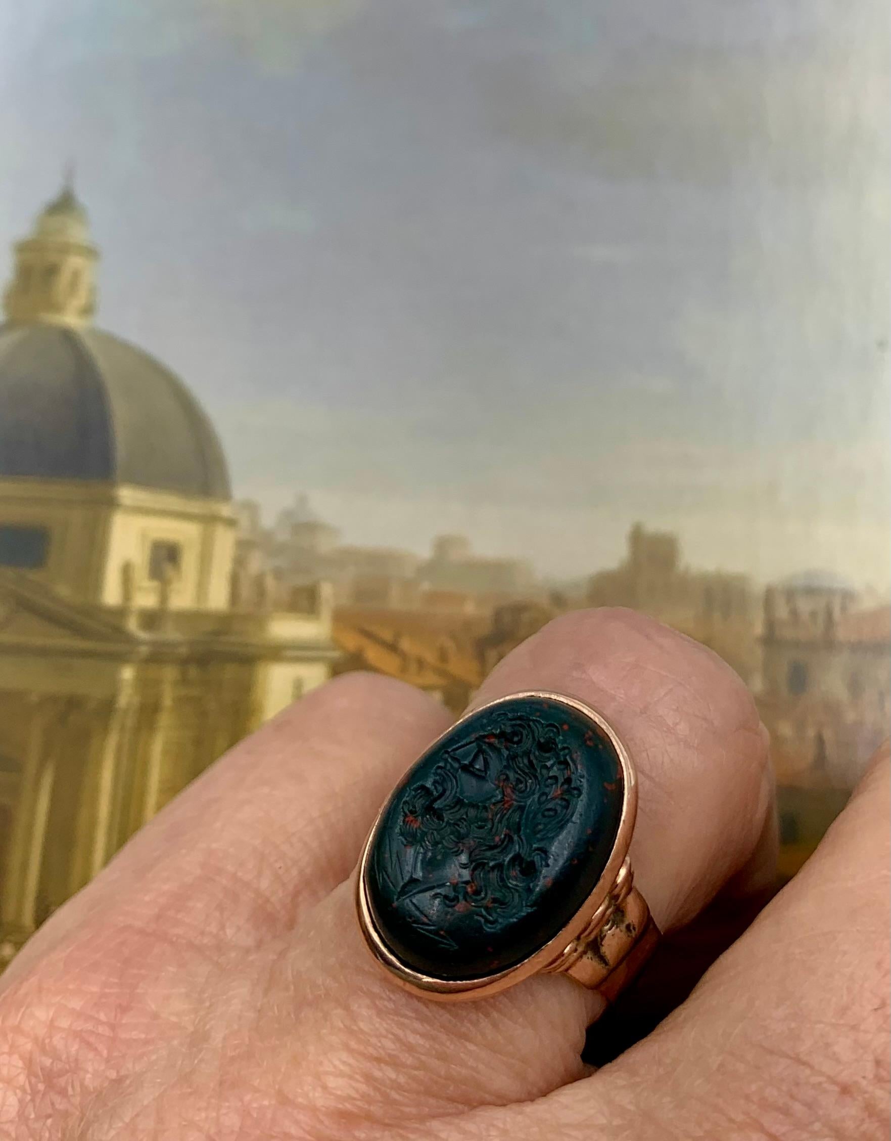 Fine Georgian period early 19th century bloodstone and 14K Rose gold intaglio signet ring depicting Zeus with bolts of lightning. The oval shaped bloodstone with rich natural red inclusions is cabochon shaped rather than flat, as are most intaglio