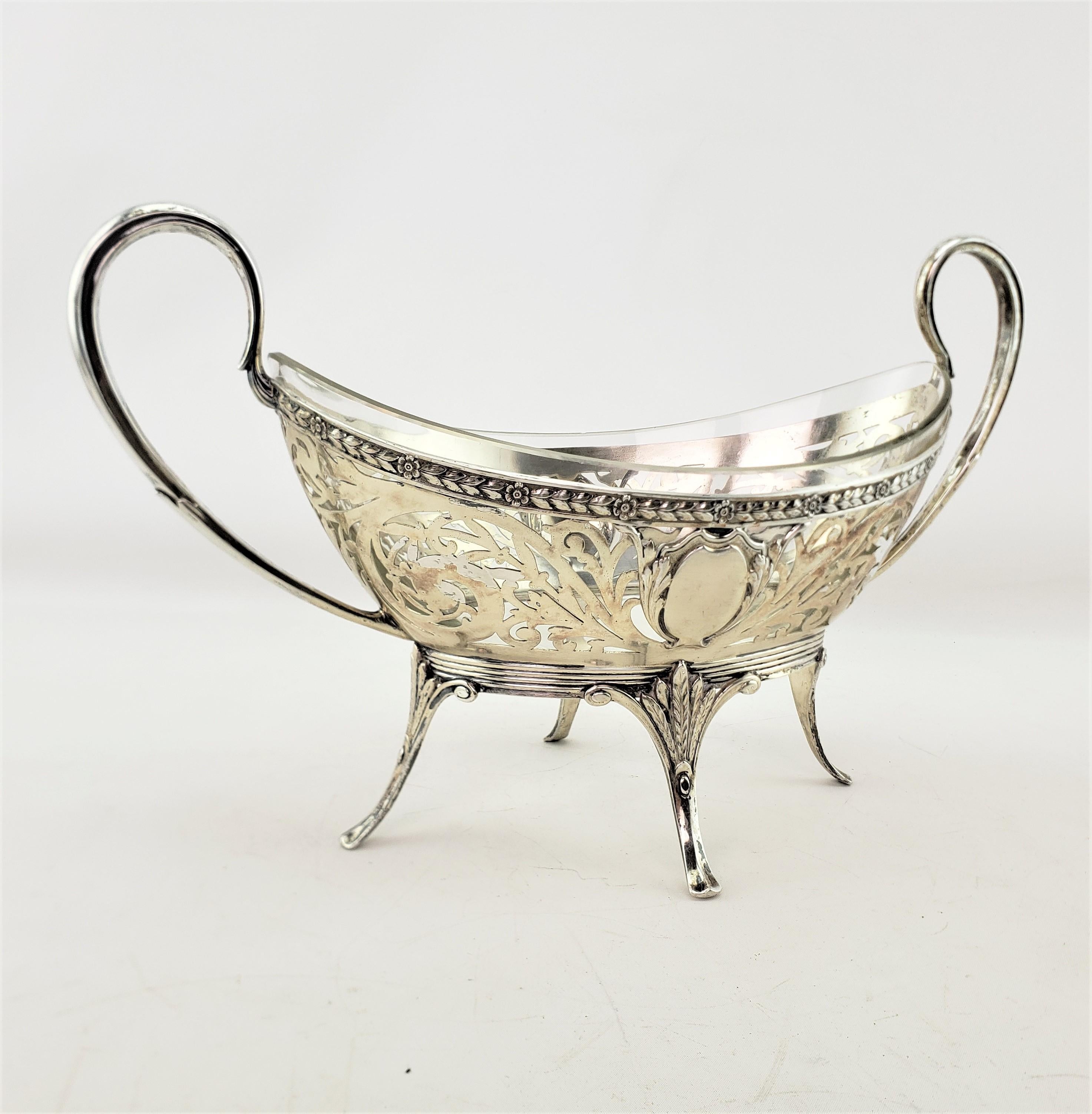 This antique centerpiece is possibly hallmarked by an unknown maker, but originated from Germany and dates to approximately 1880 and done in a period Victorian style. The basket is composed of Condinental or .800 silver and has large curled handles,
