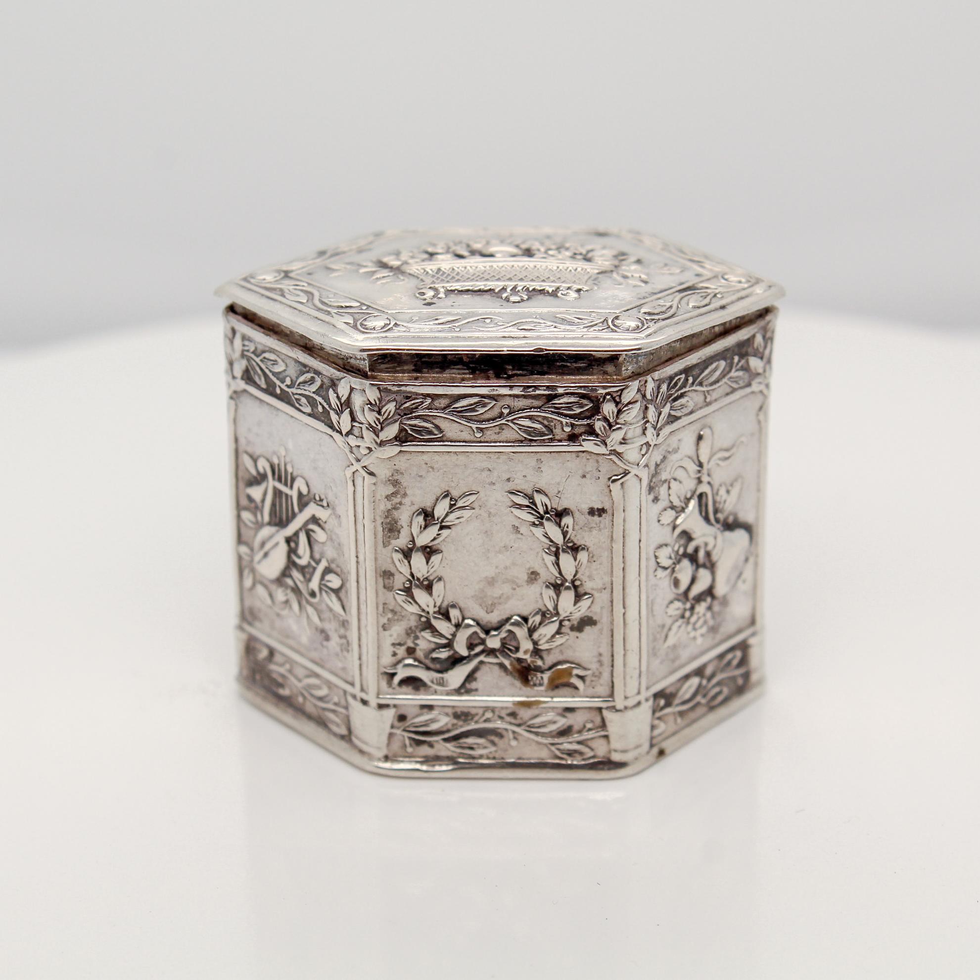 A fine antique German silver vanity or snuff box.

In 800 coin silver.

Decorated throughout with elaborate embossed floral decorations, and other miscellaneous items such as lutes, lyres, & vials.

Simply a great diminuitive box!

Date:
Late 19th
