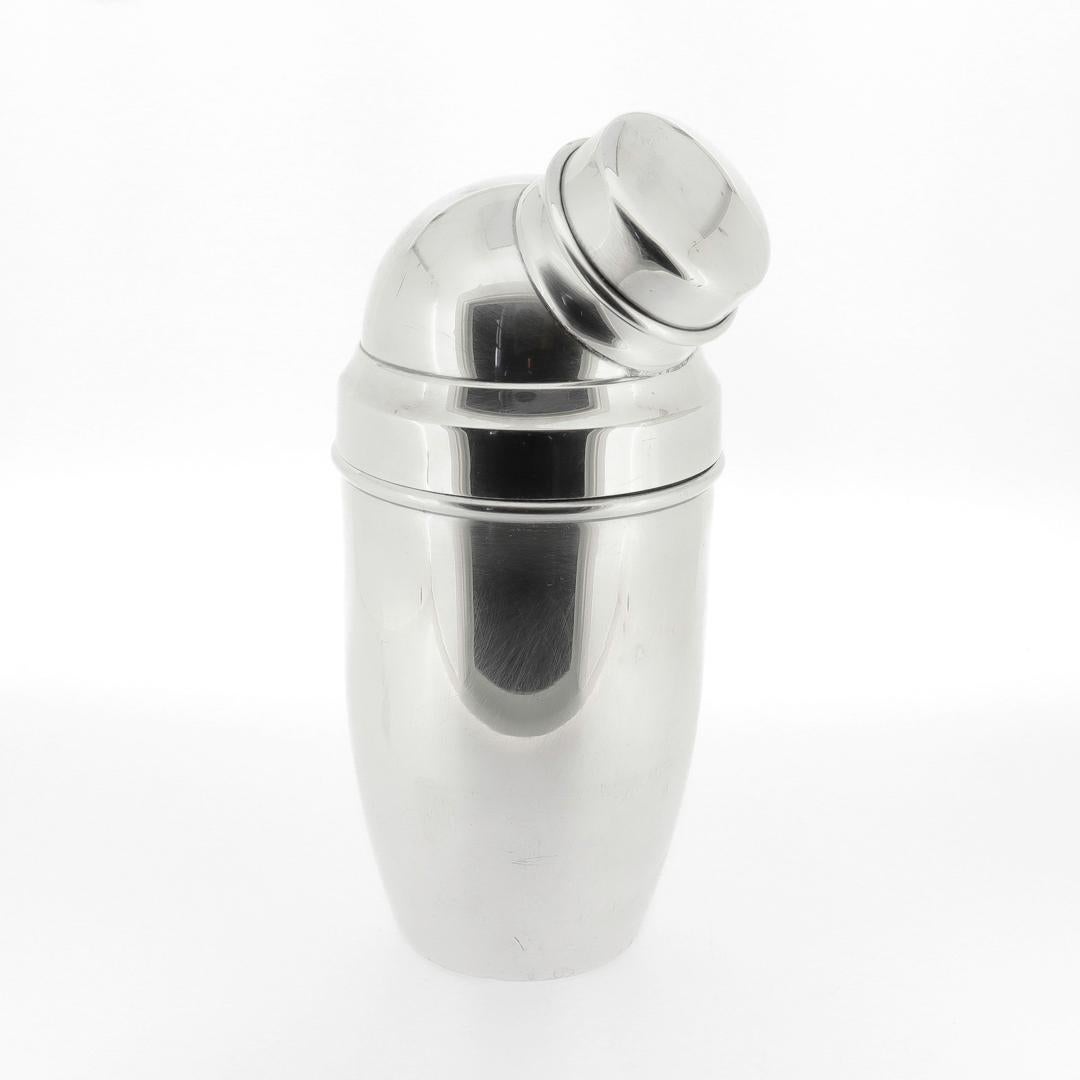 A fine antique silver plated cocktail shaker.

By Wilhelm Wolff Metallwarenfabrik.

In silver plate.

In the scale of an individual (or possibly double serving) sized shaker.

In a bullet form consisting of a vessel body, lid, and side-mounted