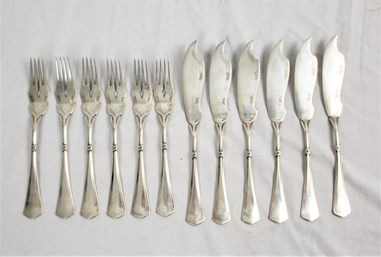 This twelve piece serving set is signed by an unknown maker, but presumed to have originated from Germany and date to approximately 1900 and done in the period Art Nouveau style. The pieces are comosed of .800 silver and contains six forks and six