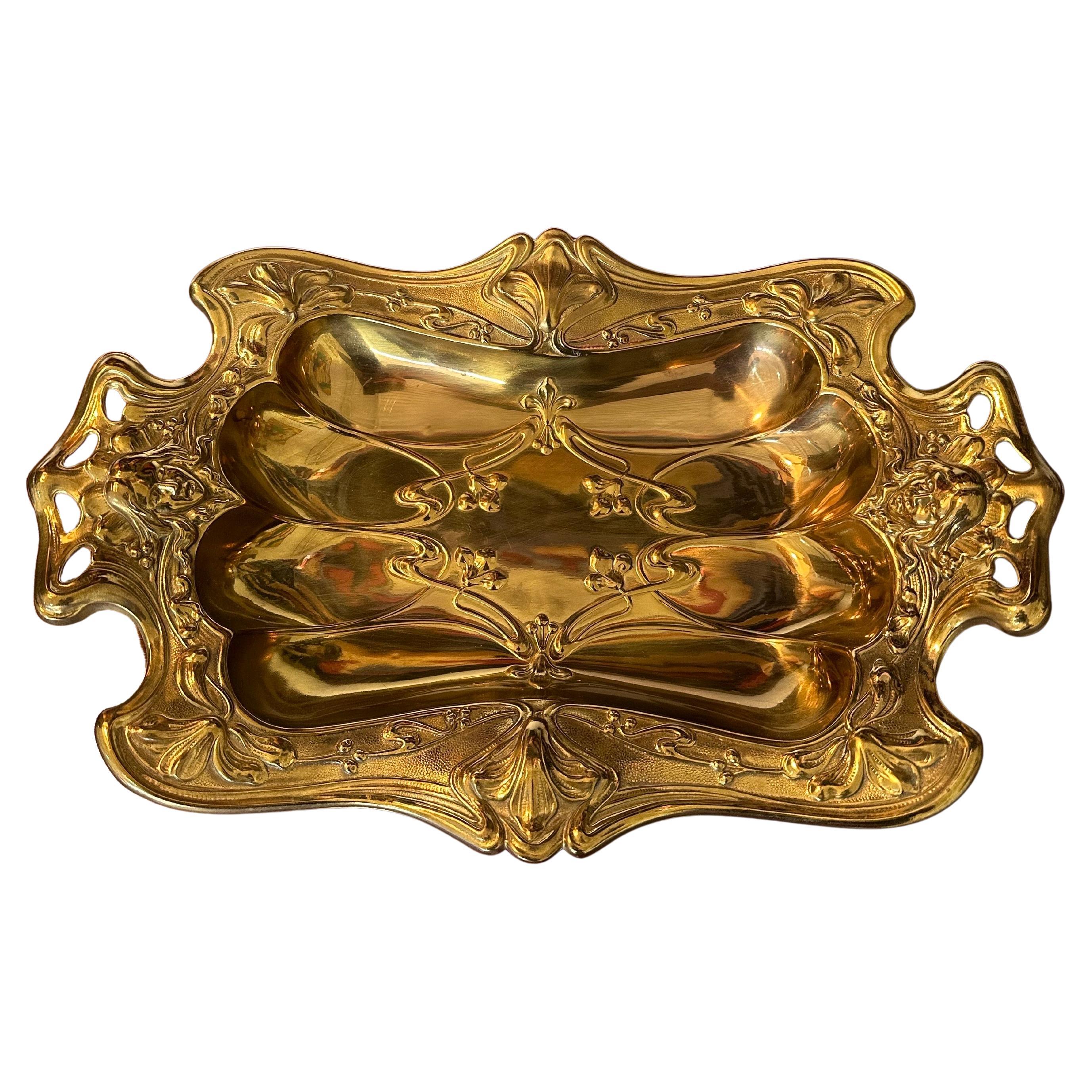 Vassoio decorativo in ottone Art Decor/ciotola da salotto/piatto decorativo. Probabilmente tedesco, anni '10 circa, con bellissimi dettagli di foglie e viti stilizzate intorno ai bordi e all'interno del vassoio con un volto di donna su entrambe le