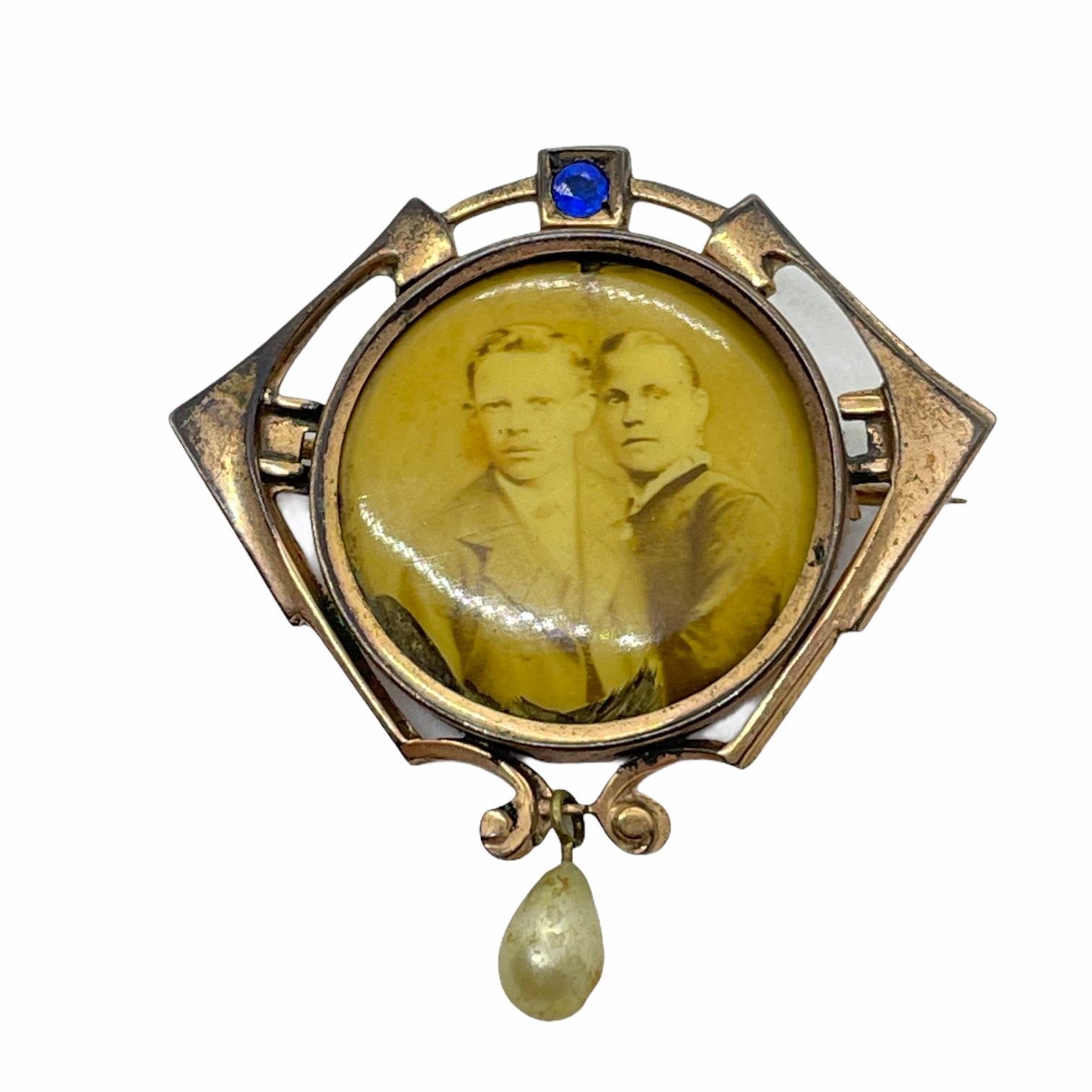 This lovely stylish sentimental brooch was made to keep a photo of loved ones. Made in Germany, circa 1900. The brooch has a picture inside. It has a blue stone and also has a hanging fresh water pearl on it.
A very pretty piece of antique