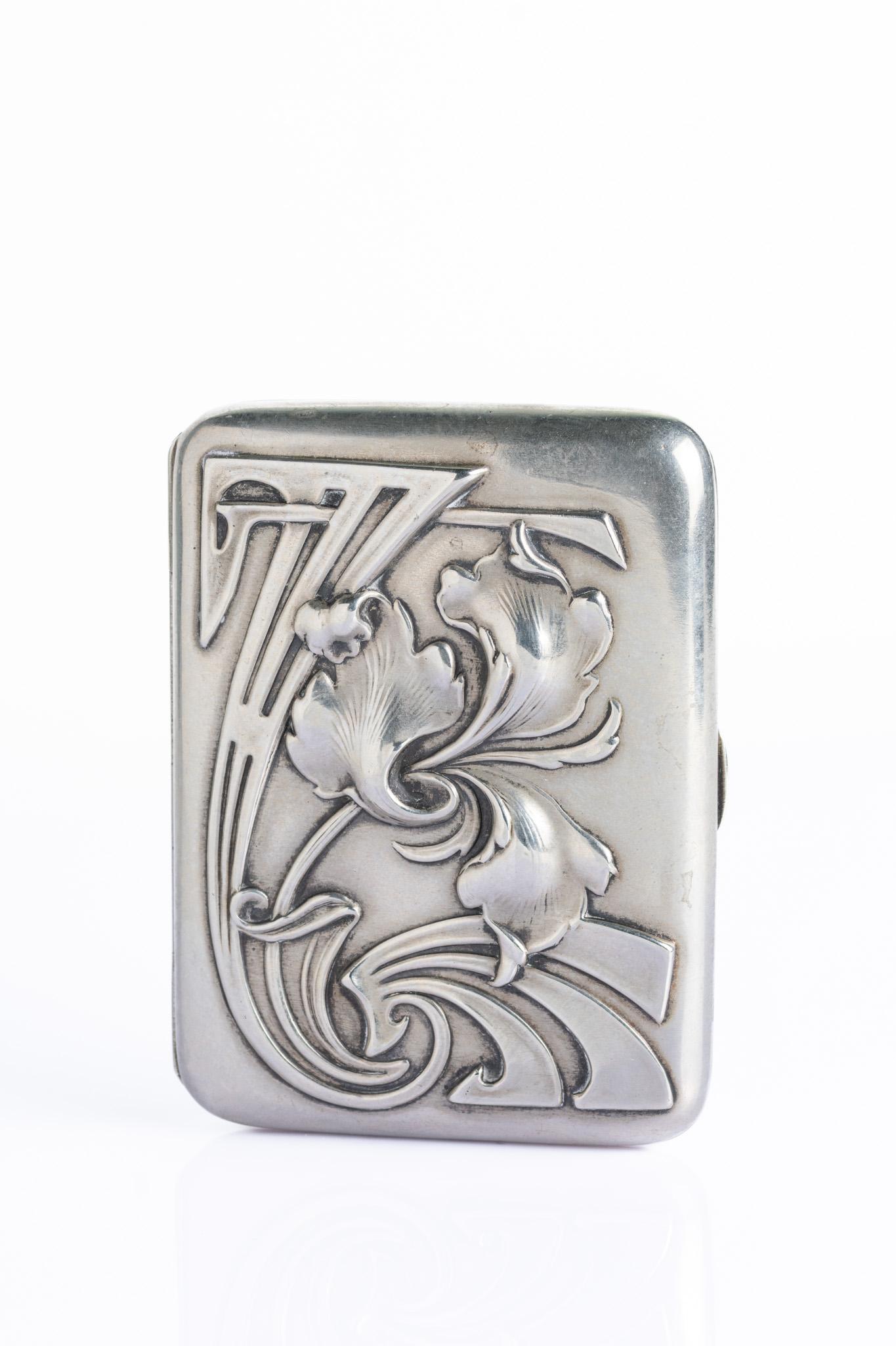 Un magnifique étui à cigarettes Art nouveau datant d'environ 1900. Le couvercle est richement décoré en haut-relief d'un motif floral fluide, de courbes et de lignes en coup de fouet caractéristiques du mouvement Jugendstil. L'intérieur est